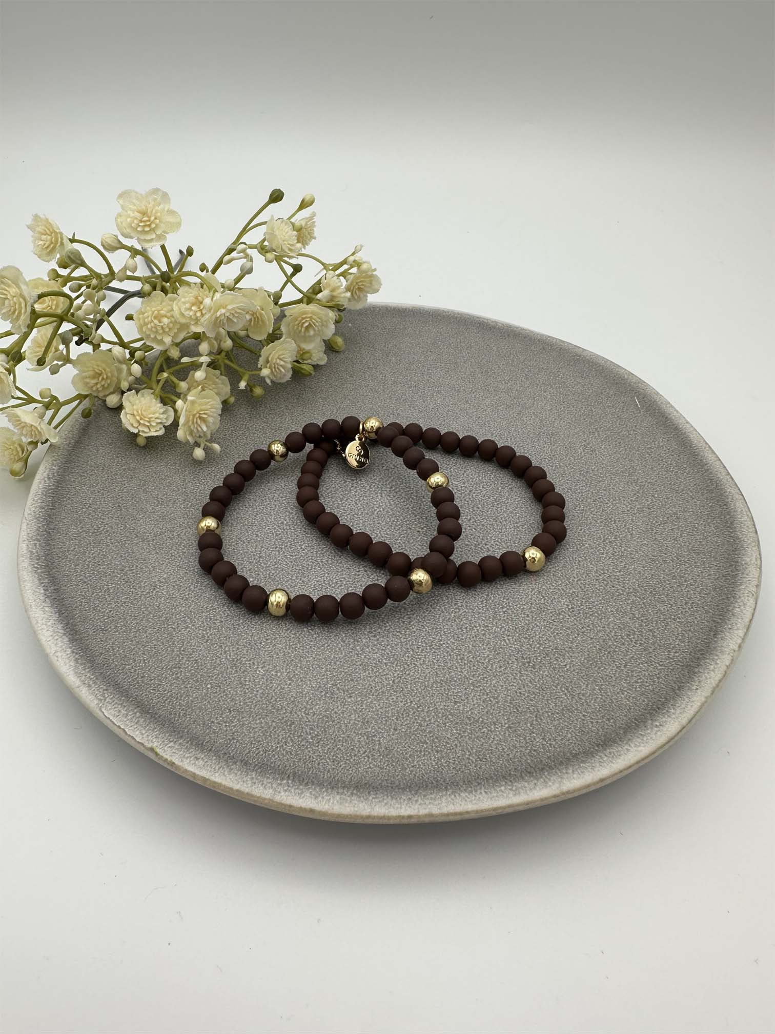 Zwei elastische braune Perlenarmbaender mit goldfarbenen Akzenten