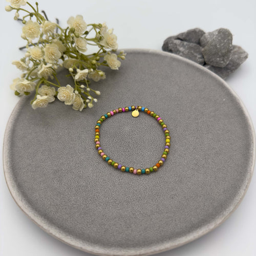 Feines elastisches Armband mit bunten Glasperlen und kleinen goldfarbenen Perlen