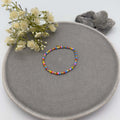 Feines elastisches Armband mit bunten Glasperlen und goldfarbenen Akzenten