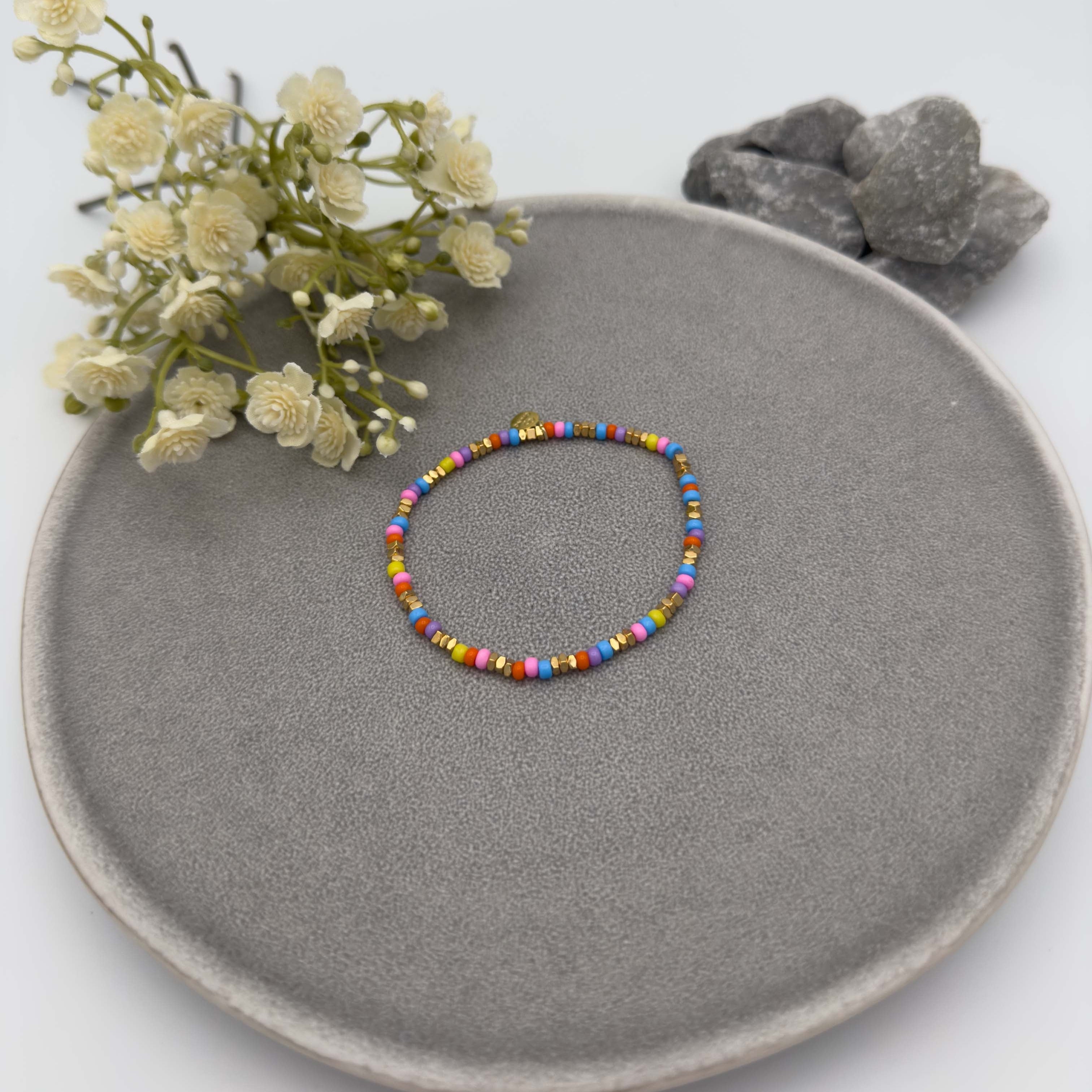 Feines elastisches Armband mit bunten Glasperlen und goldfarbenen Akzenten