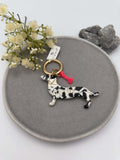 Schluesselanhaenger in Dackel Form schwarz weiss marmoriert mit rotem Knochen Anhaenger und goldenem Ring