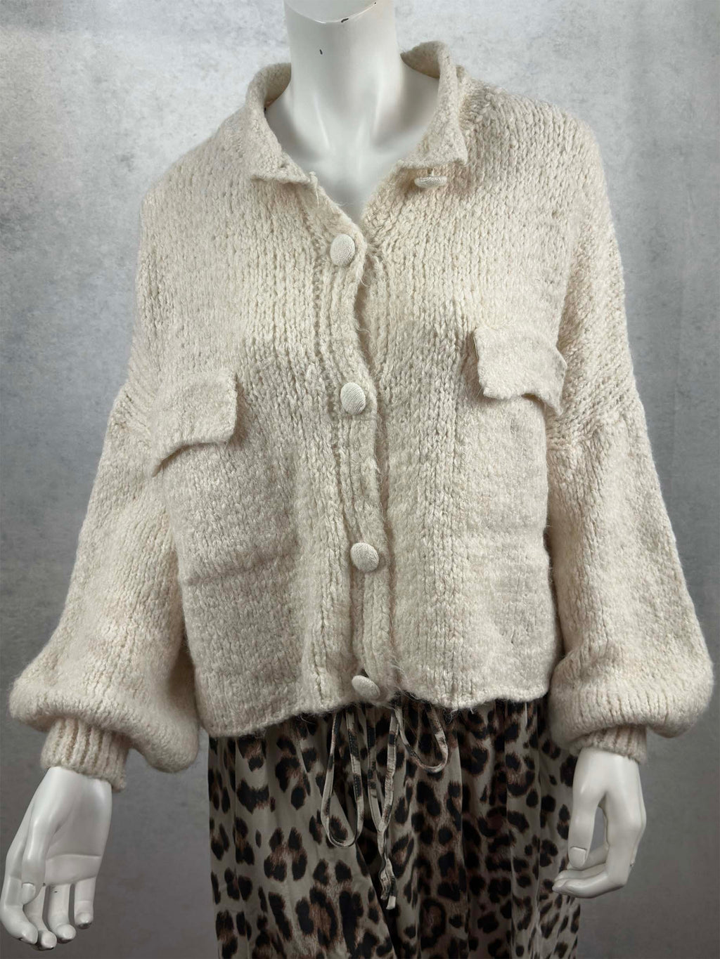 Kuschelige Damen Strickjacke in Creme mit lockerem Schnitt, aufgesetzten Taschen und grossen Knopfverschluessen.