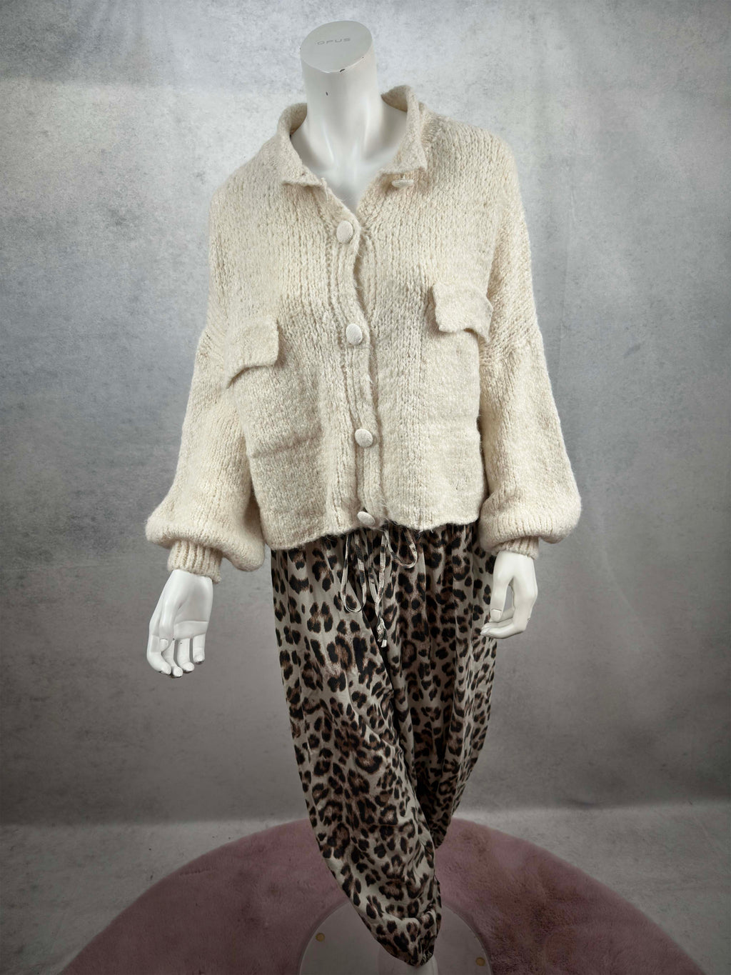 Kuschelige Damen Strickjacke in Creme mit lockerem Schnitt, aufgesetzten Taschen und grossen Knopfverschluessen in kombination mit Leo Hose Hell
