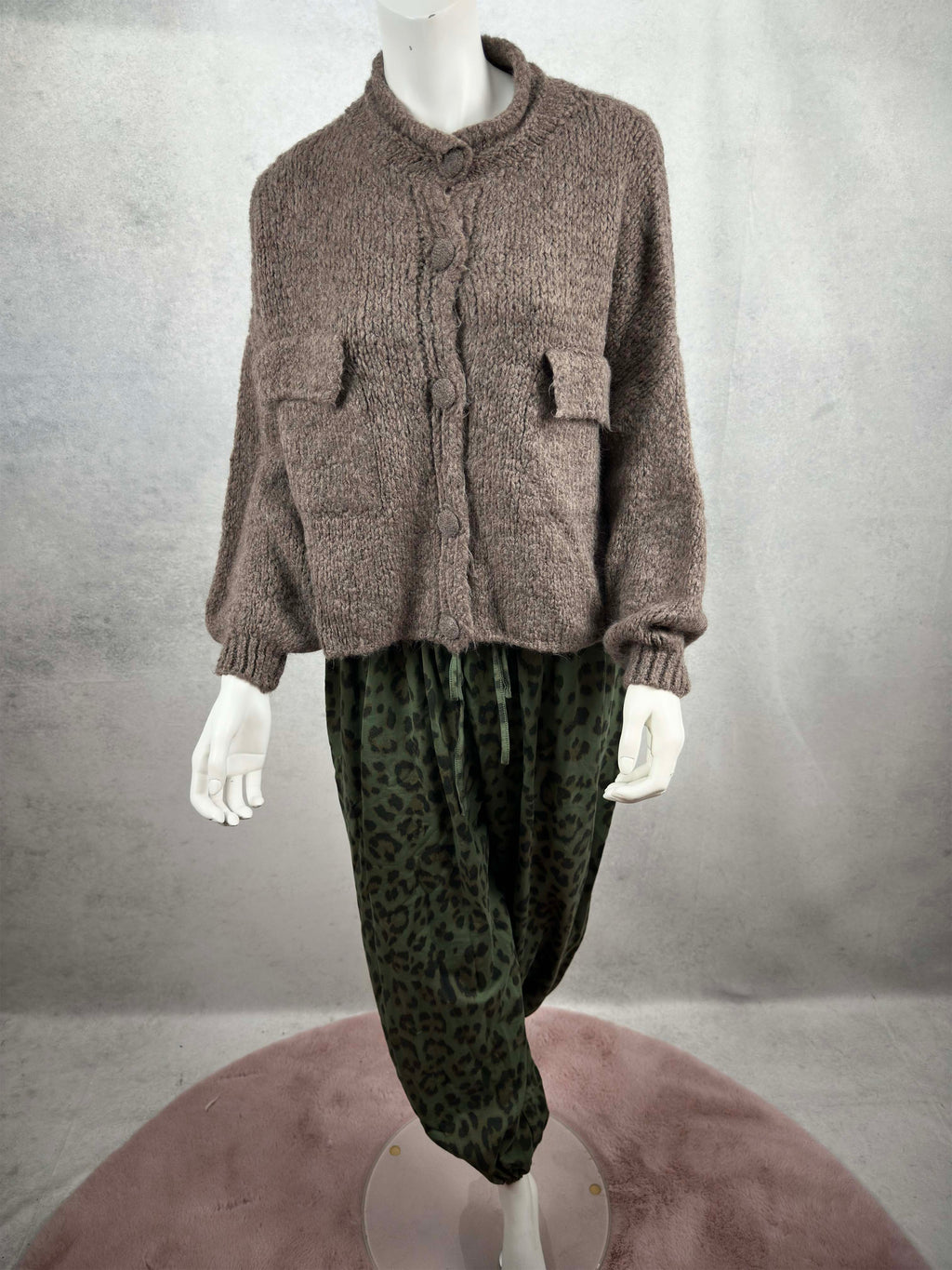 Kuschelige Damen Strickjacke in Taupe mit lockerem Schnitt, aufgesetzten Taschen und grossen Knopfverschluessen in Kombination mit Leo Hose gruen