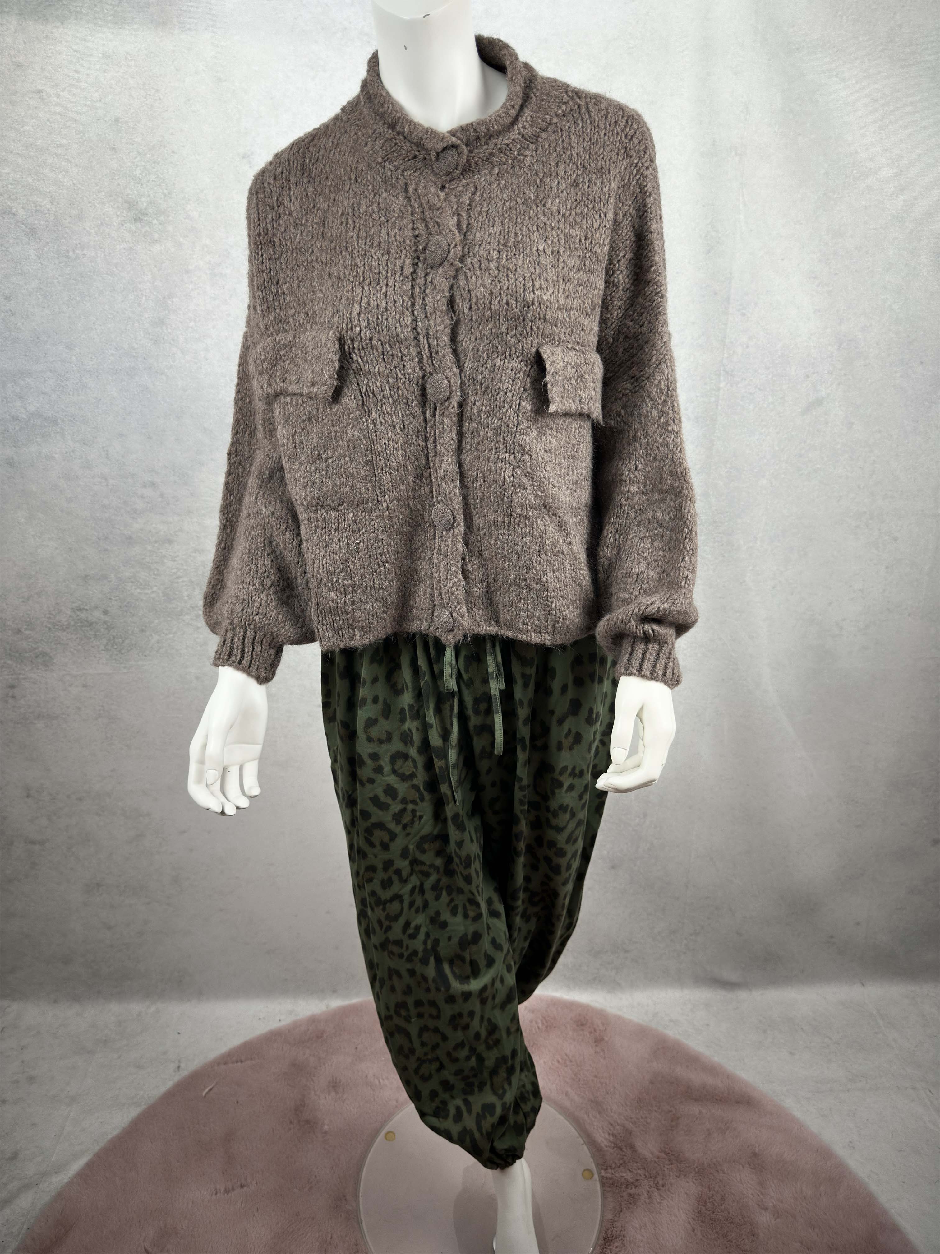 Kuschelige Damen Strickjacke in Taupe mit lockerem Schnitt, aufgesetzten Taschen und grossen Knopfverschluessen in Kombination mit Leo Hose gruen