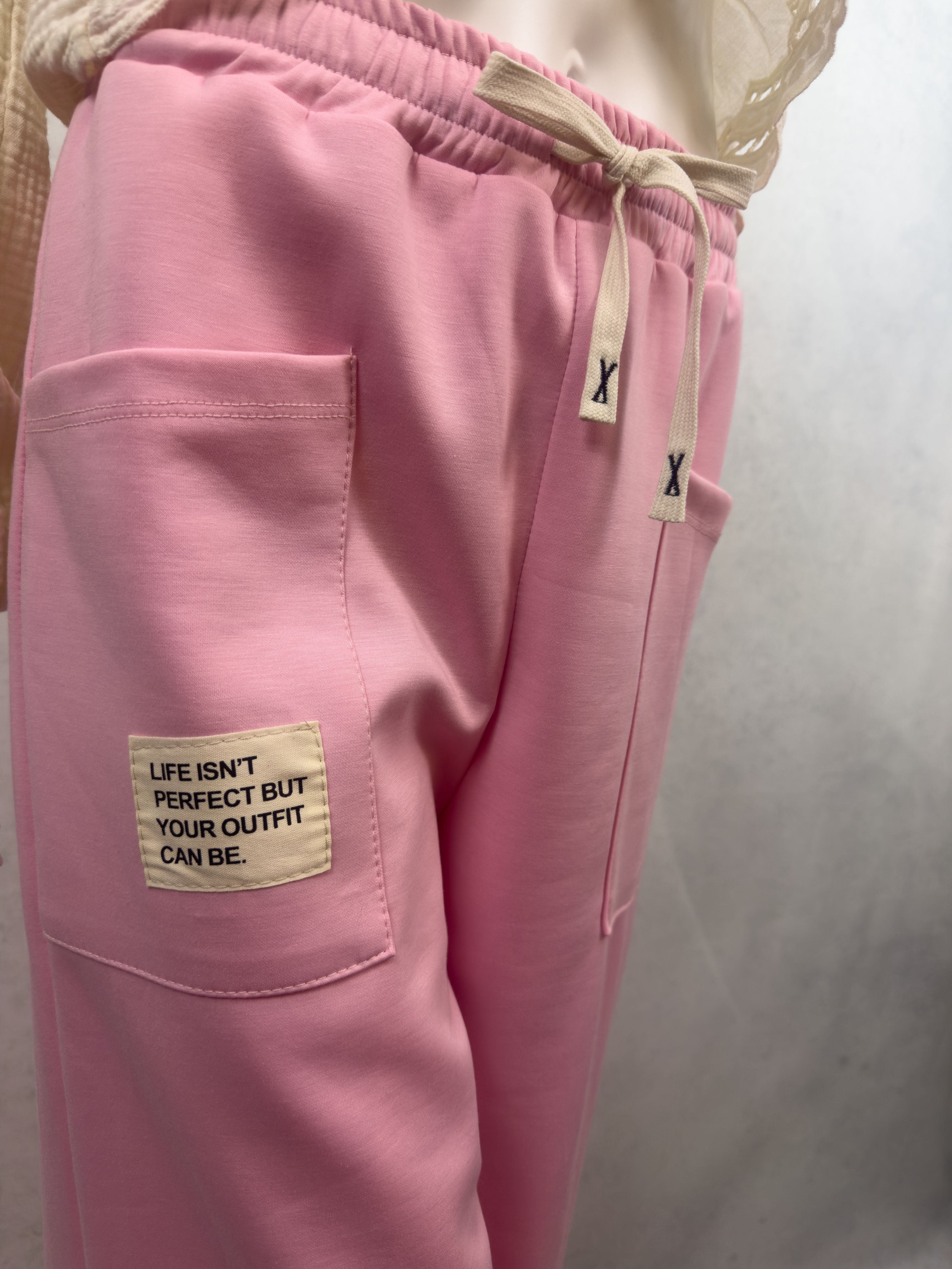 Rosa Sweathose mit aufgesetzter Fronttasche, hellem Stoffpatch mit dem Schriftzug Life isnt perfect but your outfit can be und elastischem Bund mit Kordel