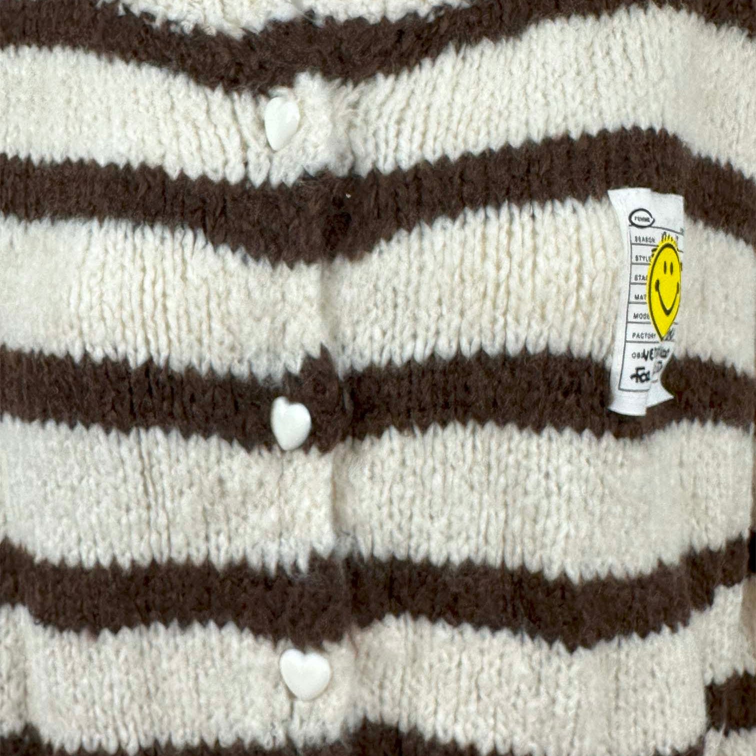Nahaufnahme der Herz Knoepfe an gestreiftem Strickcardigan