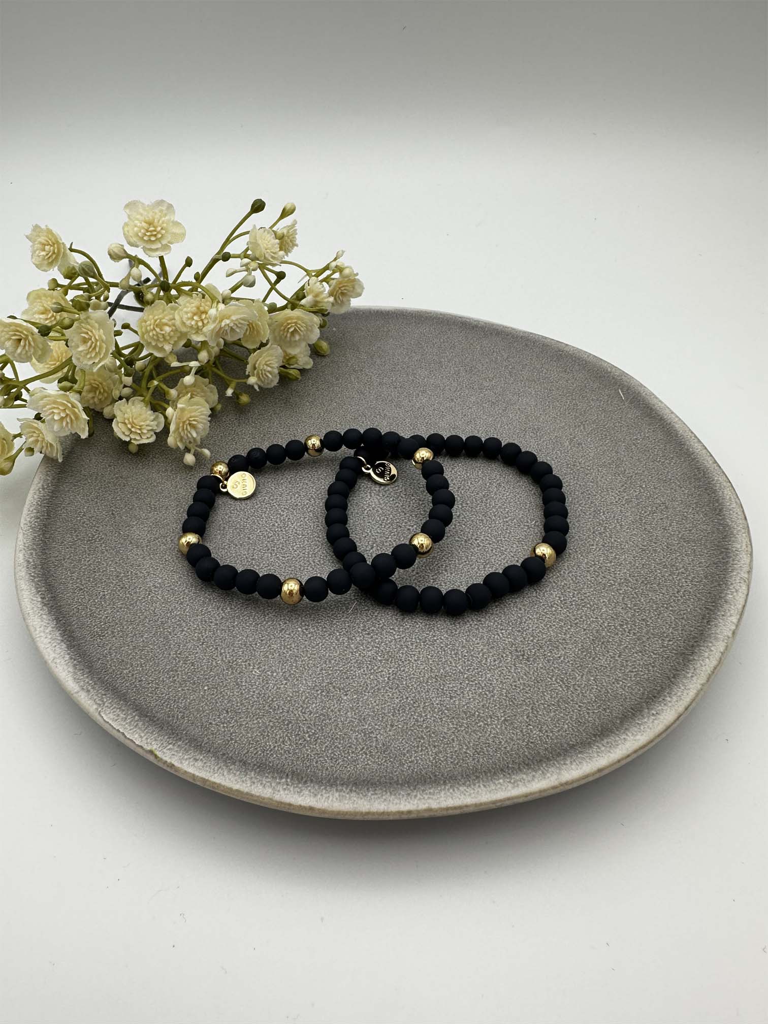 Zwei elastische dunkelblaue Perlenarmbaender mit goldfarbenen Akzenten