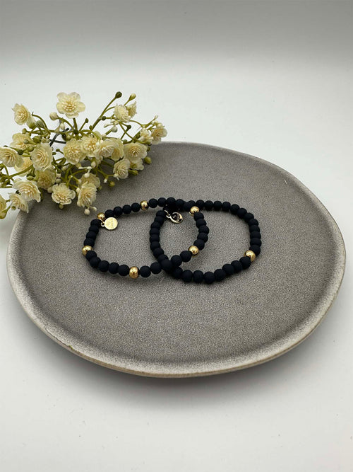 Zwei elastische dunkelblaue Perlenarmbaender mit goldfarbenen Akzenten