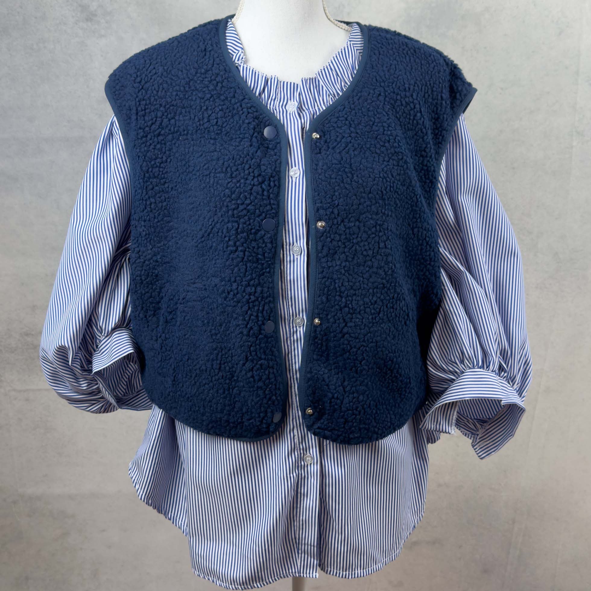 Dunkelblaue Teddyweste mit Druckknoepfen und abgerundetem Saum