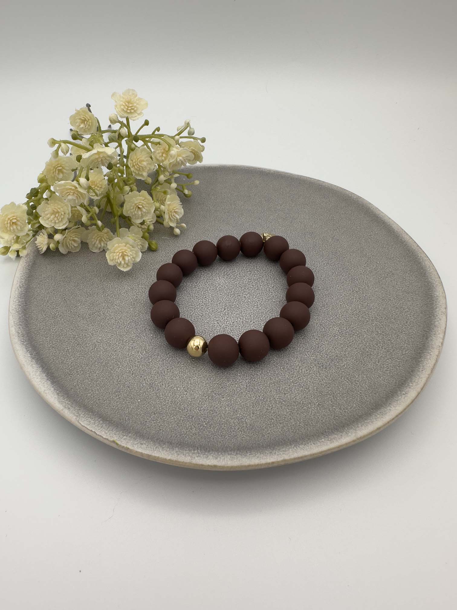 Elastisches Armband mit matten dunkelbraunen Perlen und einer goldenen Akzentkugel