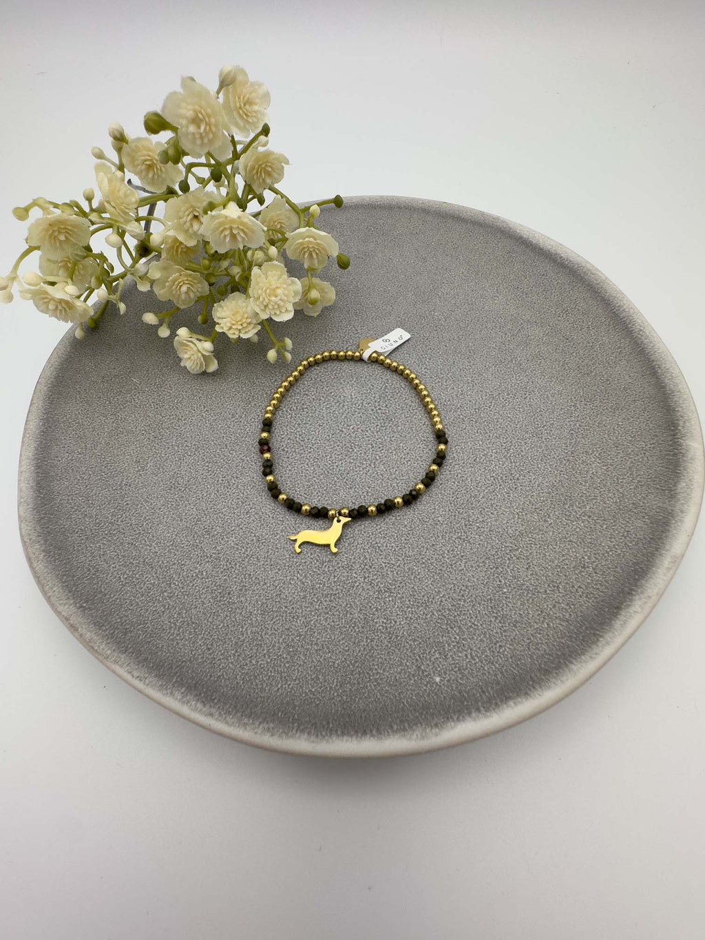 Schwarzes Perlenarmband mit goldfarbenem Dackel Anhaenger.