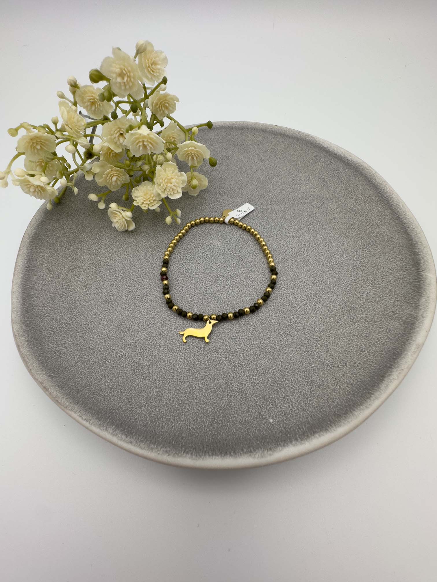 Schwarzes Perlenarmband mit goldfarbenem Dackel Anhaenger.