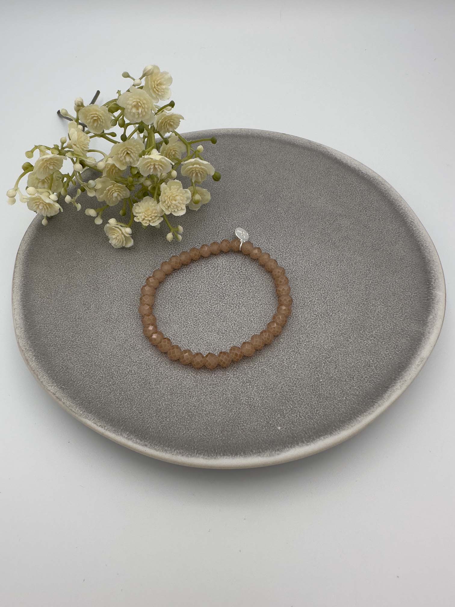 Elastisches Perlenarmband mit braunen facettierten Perlen.