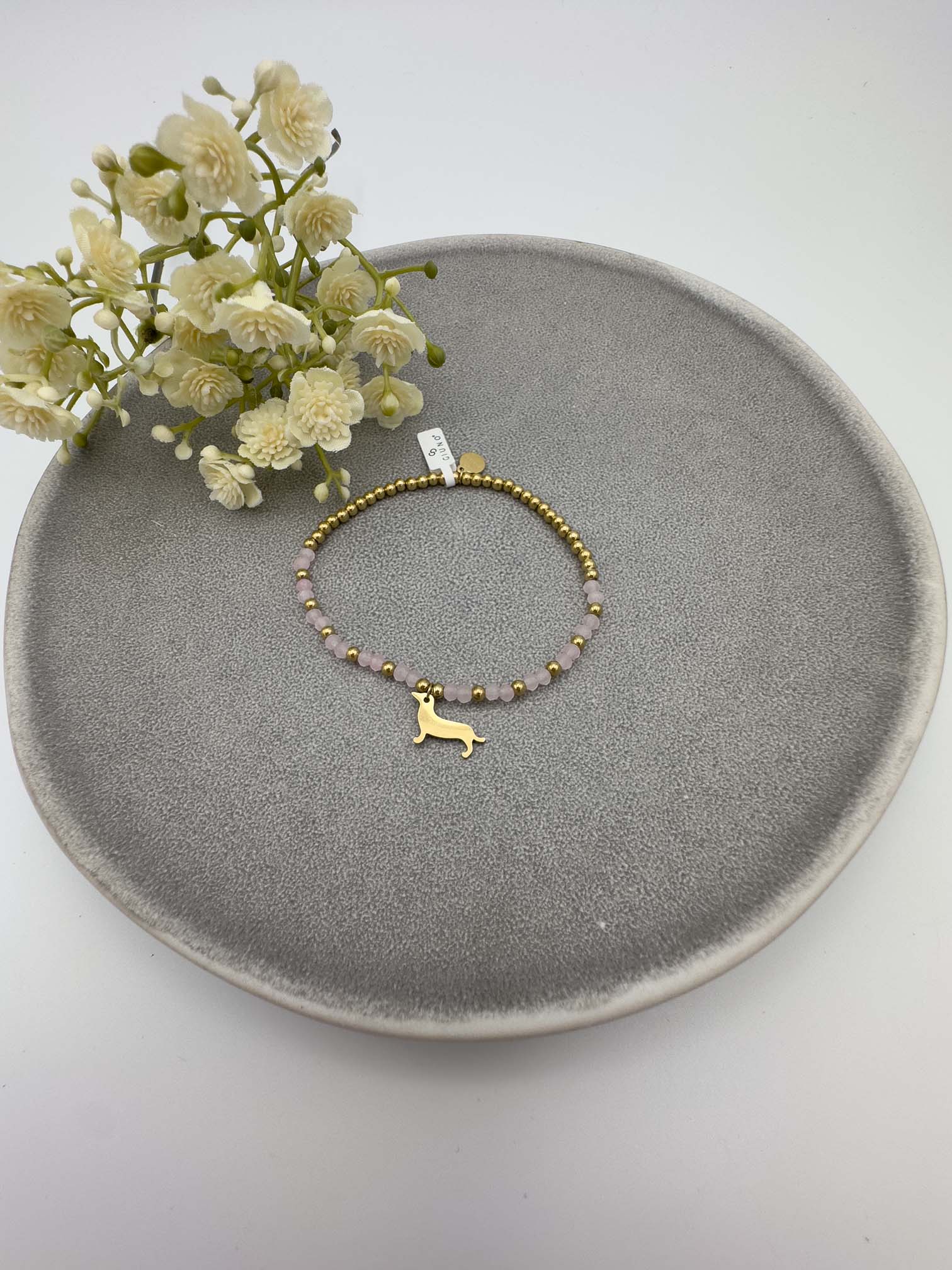 Rosa Perlenarmband mit goldfarbenem Dackel Anhaenger.