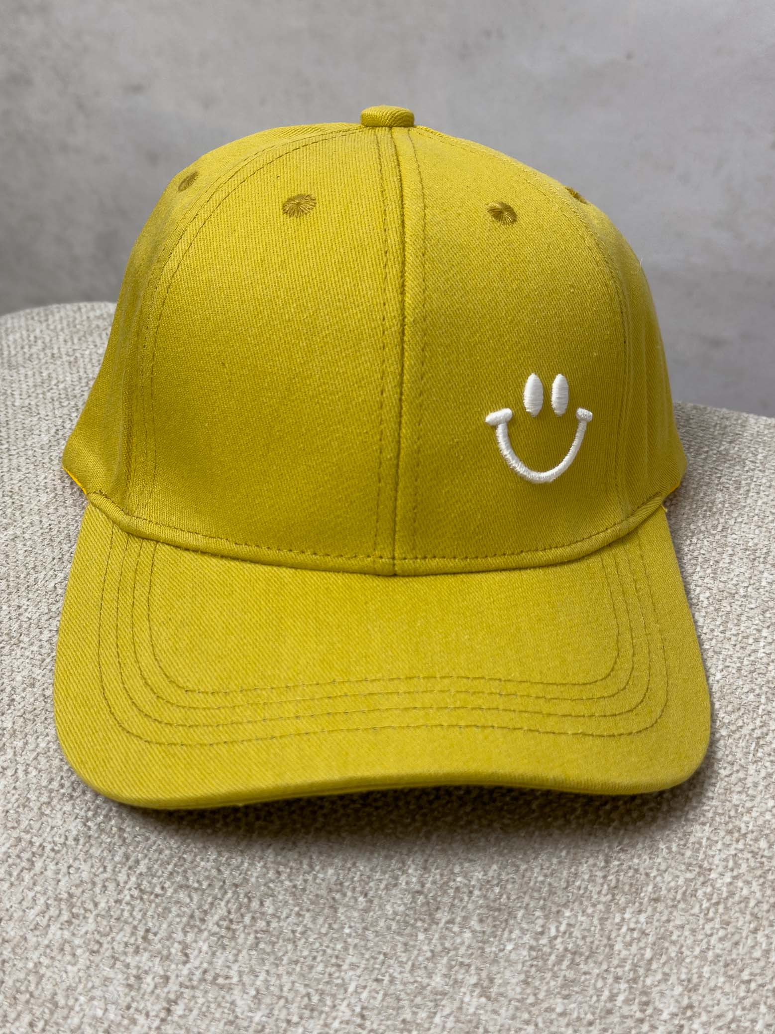 Senfgelbe Baseball Cap mit weiss gesticktem Smiley auf der Vorderseite