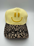 Hellgelbe Baseball Cap mit gelbem gesticktem Smiley auf der Vorderseite und gebogenem Schirm mit Leo-Muster