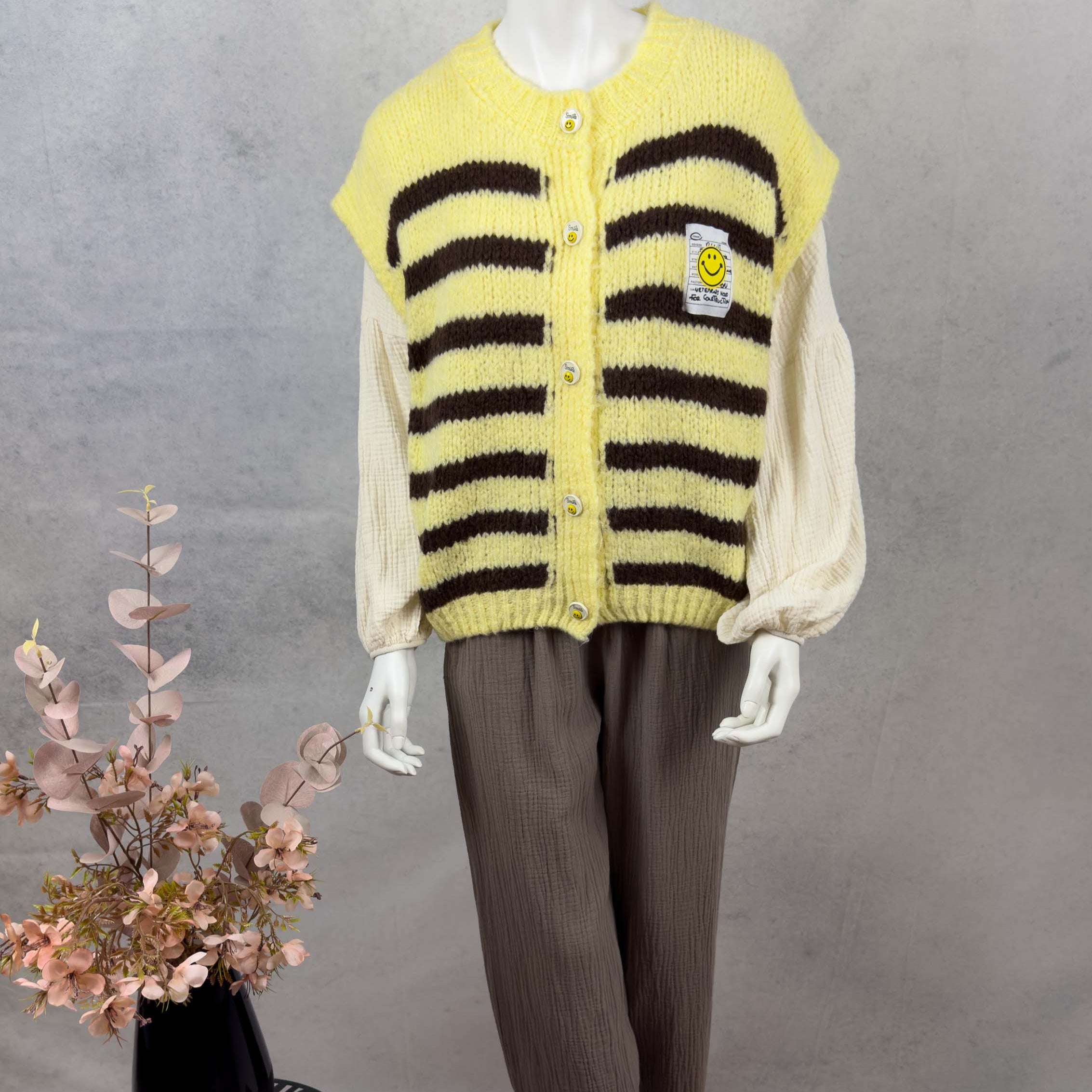 Locker geschnittener Strickcardigan in Gelb mit breiten braunen Streifen und runder Knopfleiste mit Smiley Knoepfen