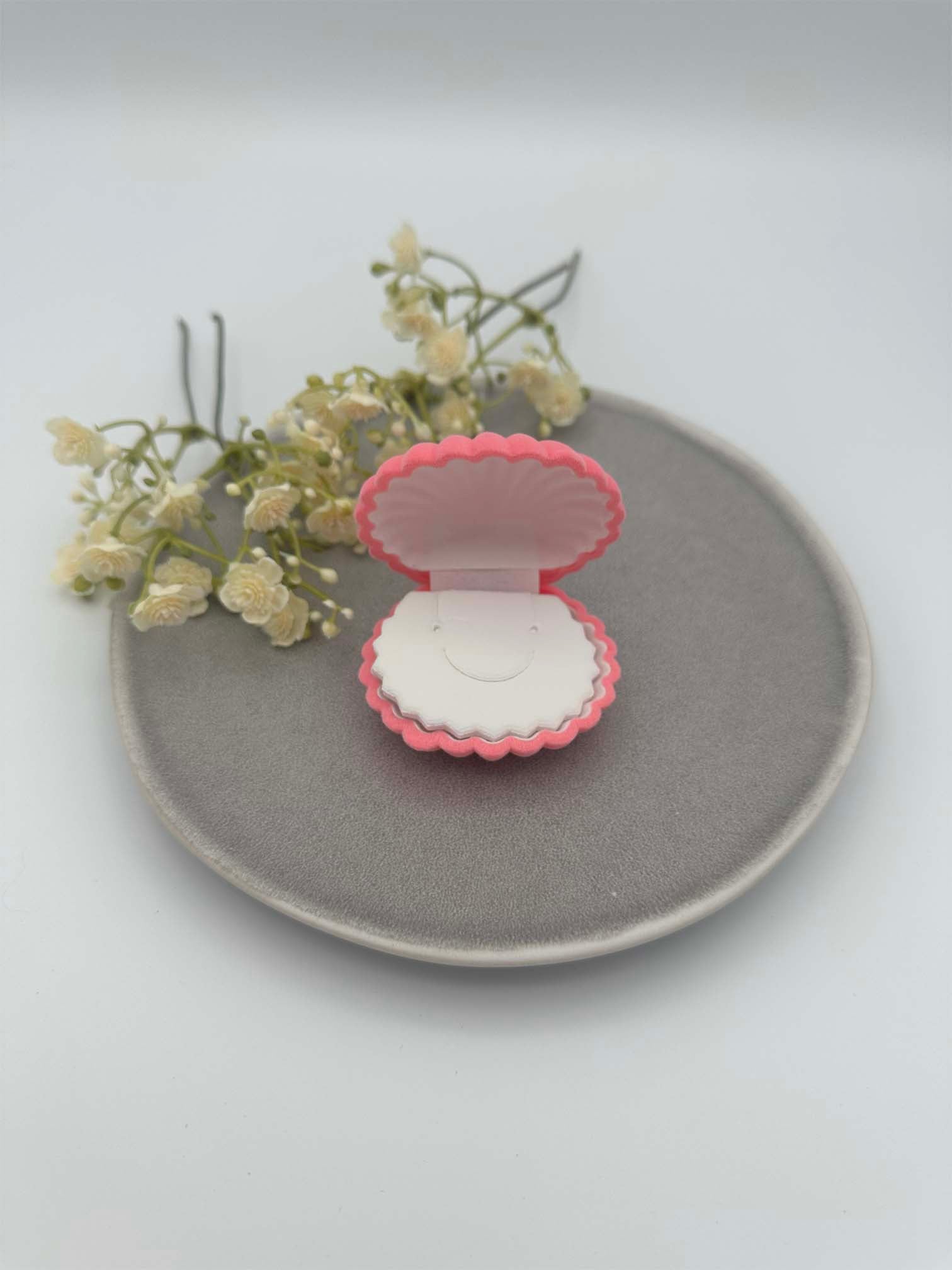 Pink Schmuckkaestchen in Muschelform, geoeffnet, mit heller Innenpolsterung zur Aufbewahrung von Schmuck.
