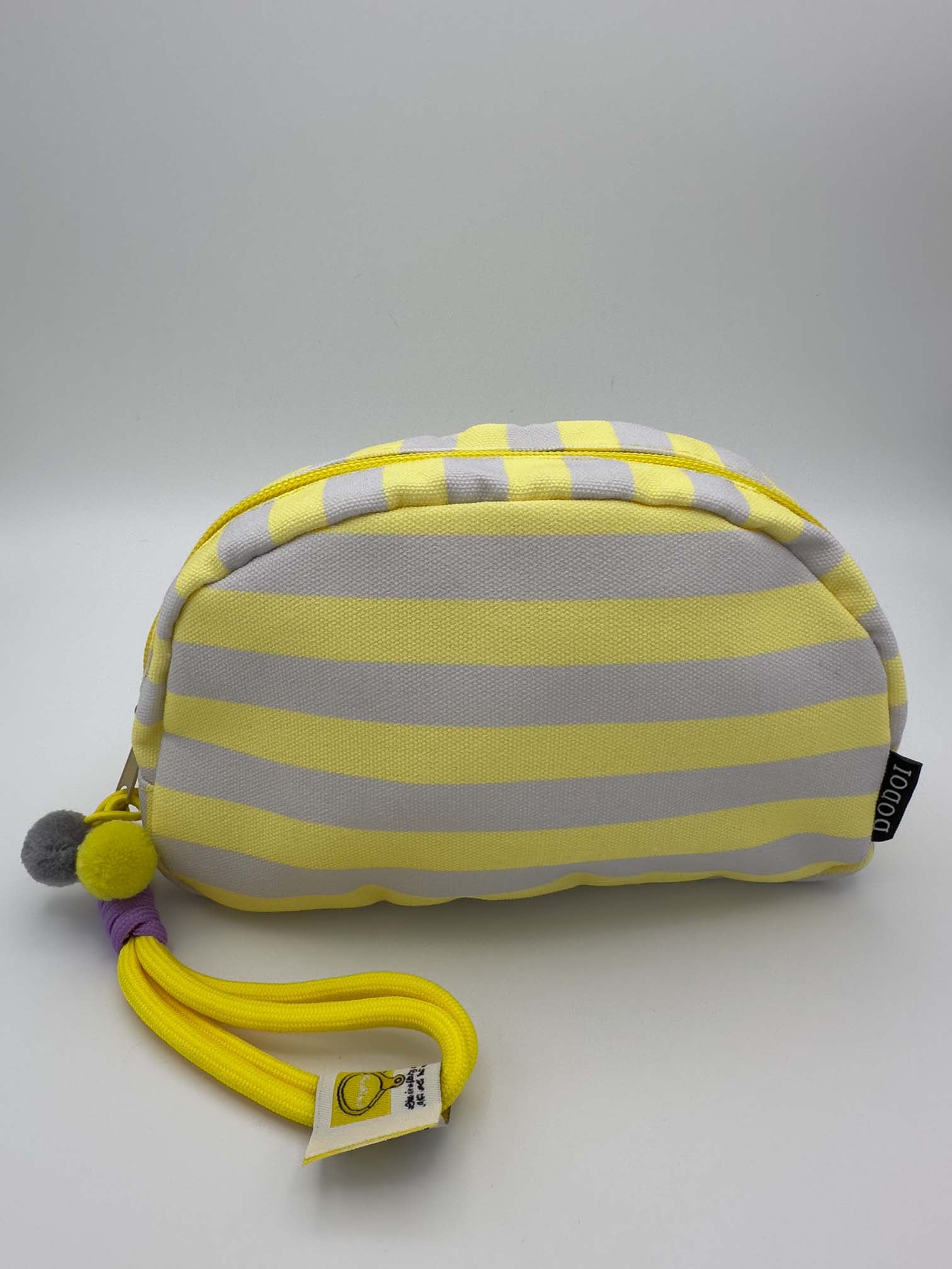 Kleine Kosmetiktasche mit gelb grauen Streifen, Reissverschluss und gelber Schlaufe mit Pompons
