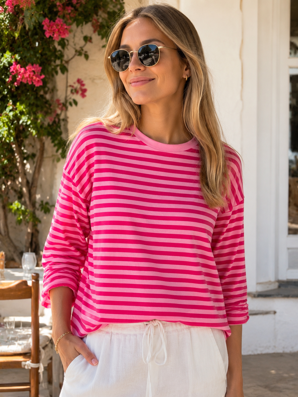 Frau traegt pink rosa gestreiftes Langarmshirt mit heller Hose