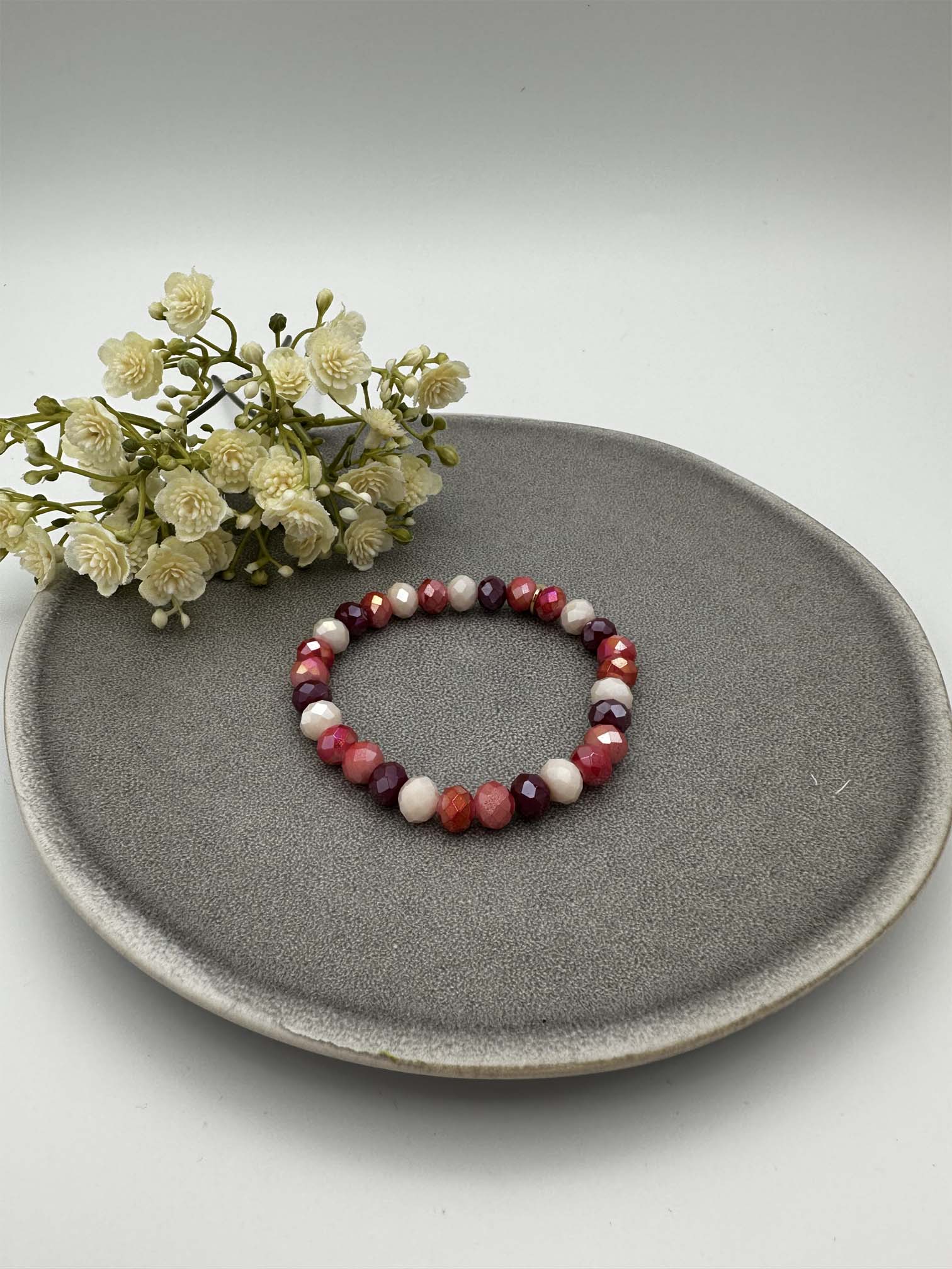 Elastisches Perlenarmband mit facettierten Perlen in Rot-, Rosa- und Beerentoenen