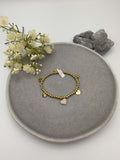 Elastisches Armband mit goldfarbenen Metallperlen und Herzanhaenger
