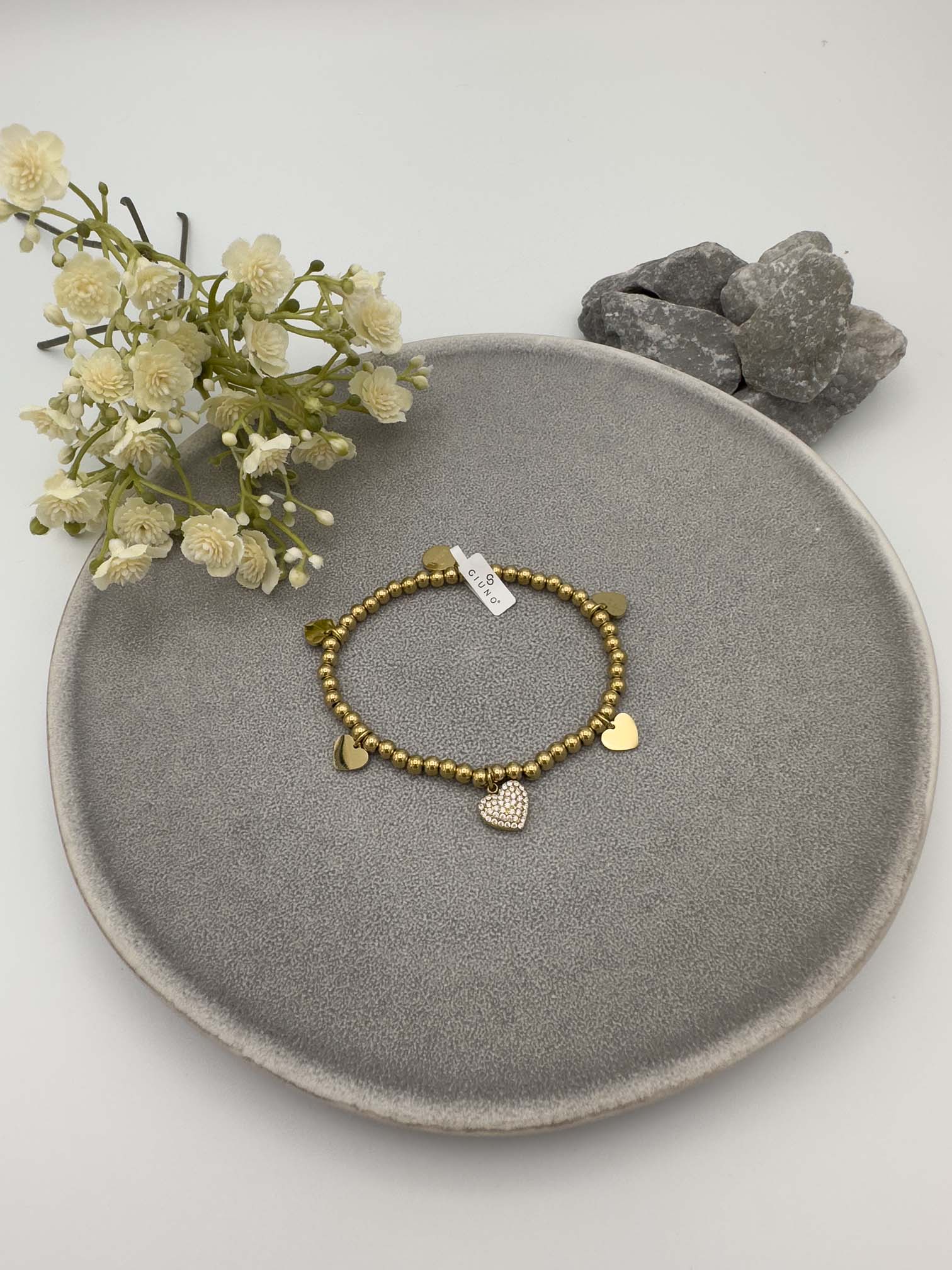 Elastisches Armband mit goldfarbenen Metallperlen und Herzanhaenger