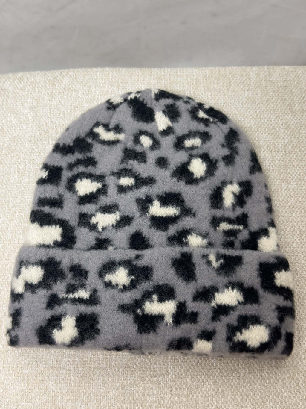 Weiche Strickmütze in Grau mit schwarzem Leopardenmuster und Umschlag