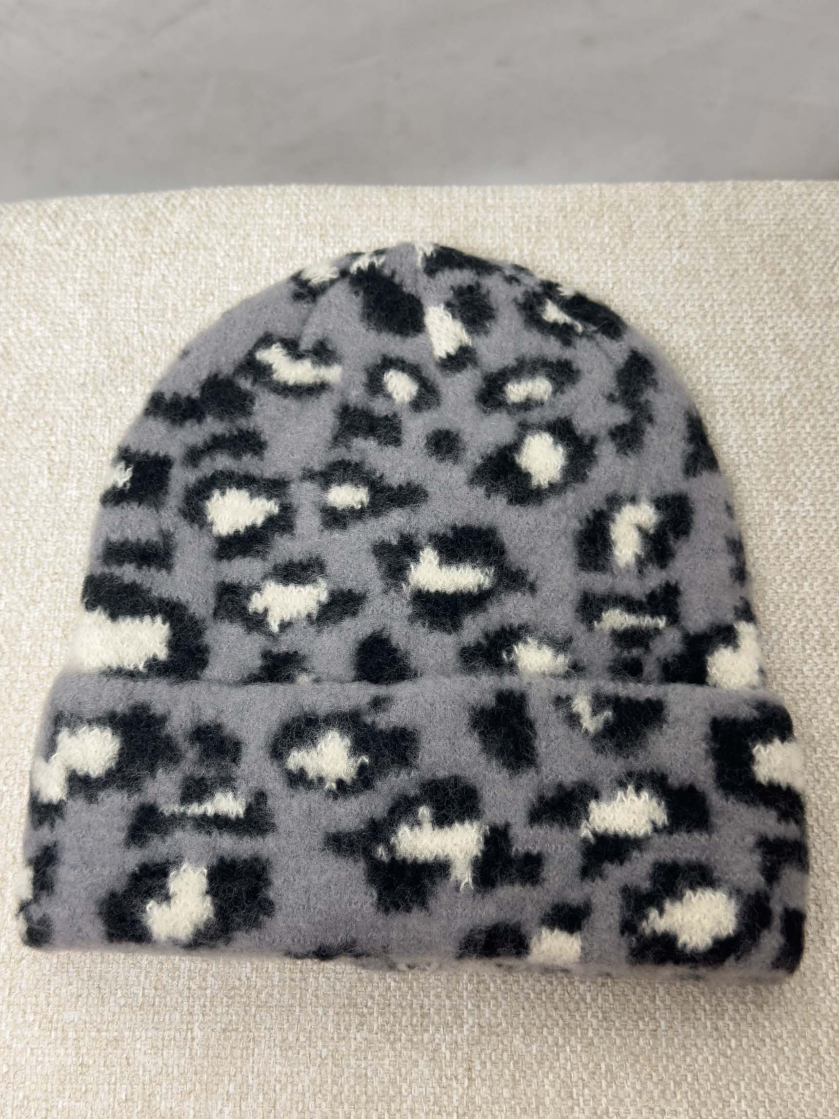 Weiche Strickmütze in Grau mit schwarzem Leopardenmuster und Umschlag