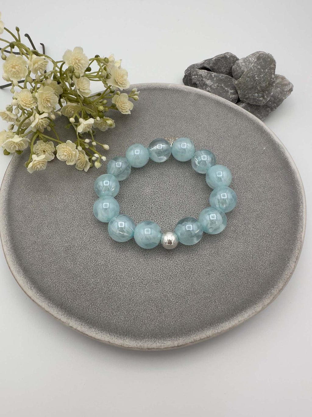 Elastisches Armband mit hellblauen Perlen und silberfarbener Kugel