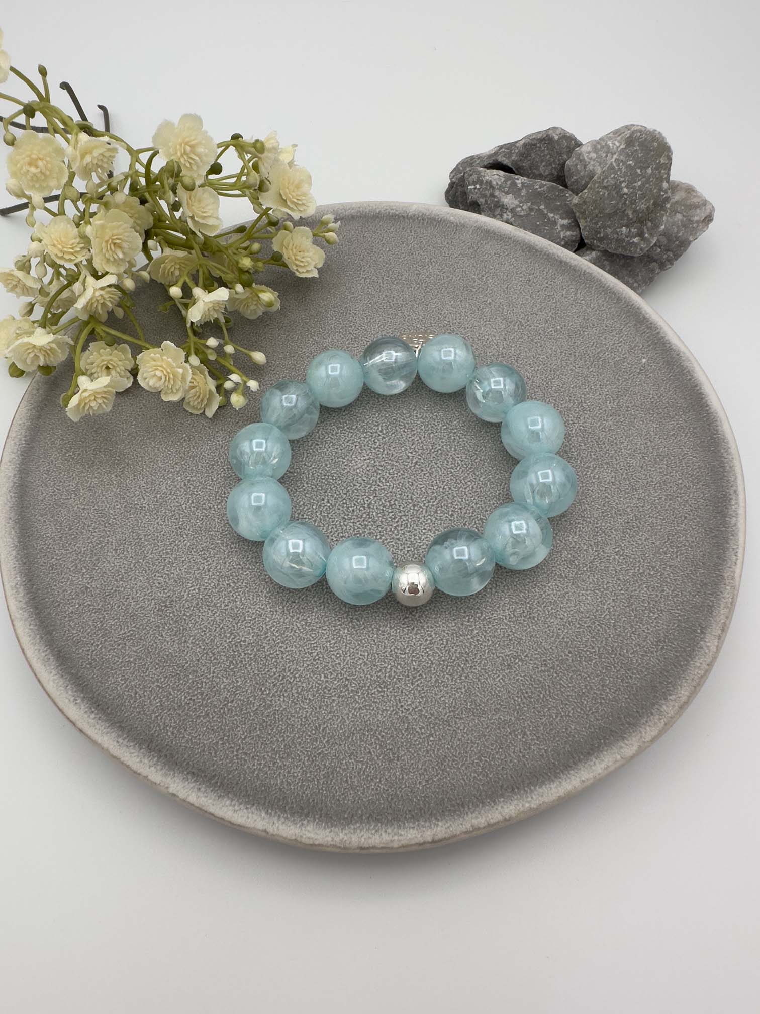 Elastisches Armband mit hellblauen Perlen und silberfarbener Kugel