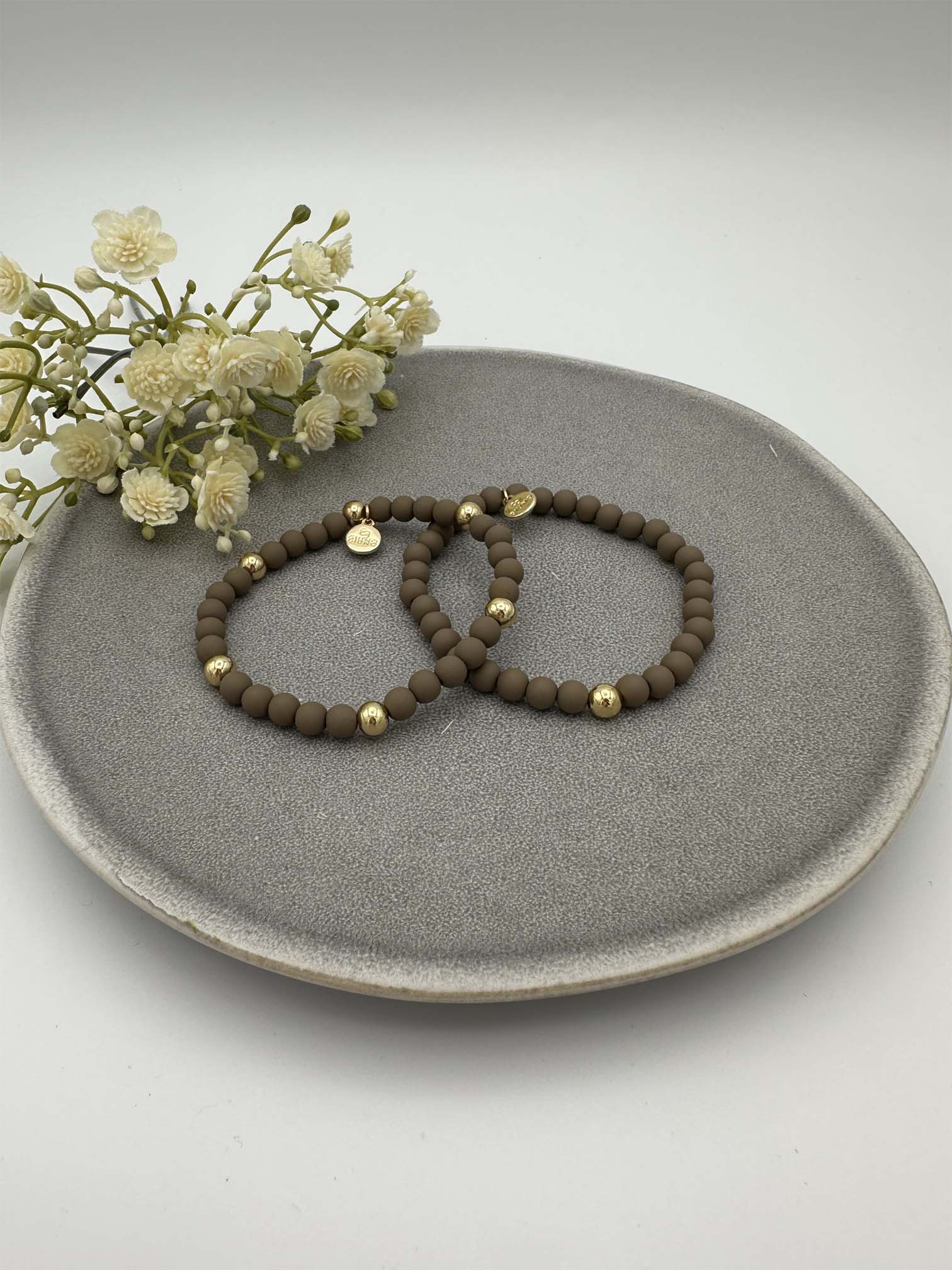 Zwei elastische khaki Perlenarmbaender mit goldfarbenen Akzenten