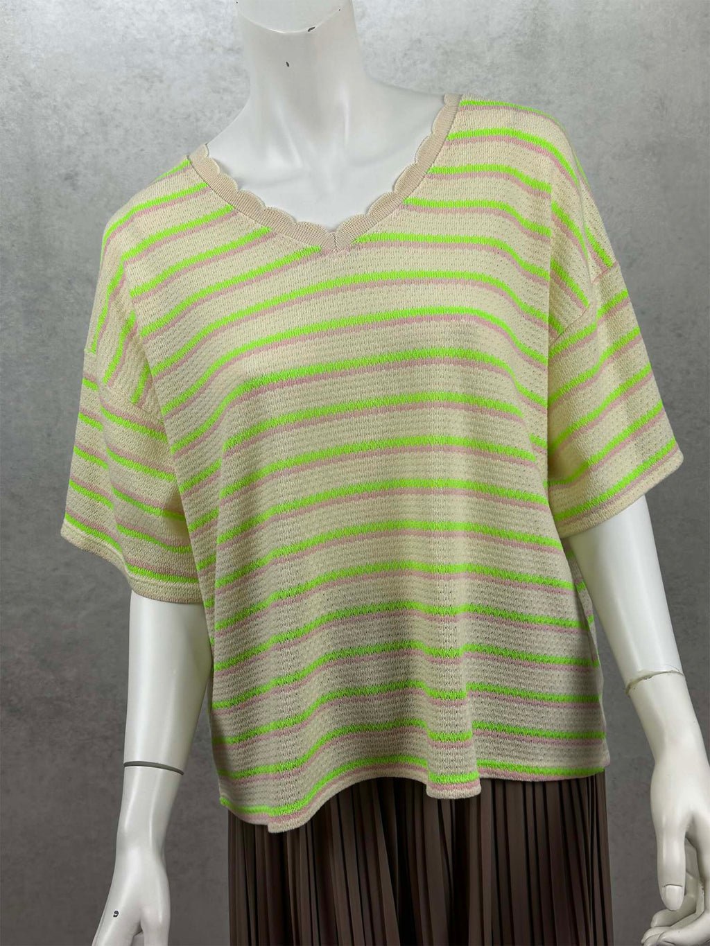 Moderner Strickshirt mit lockerer Passform, femininem V-Ausschnitt und auffaelligen Neonstreifen. Die weiche Strickstruktur und die kurzen Aermel machen ihn zum perfekten Begleiter fuer Fruehling und Sommer.