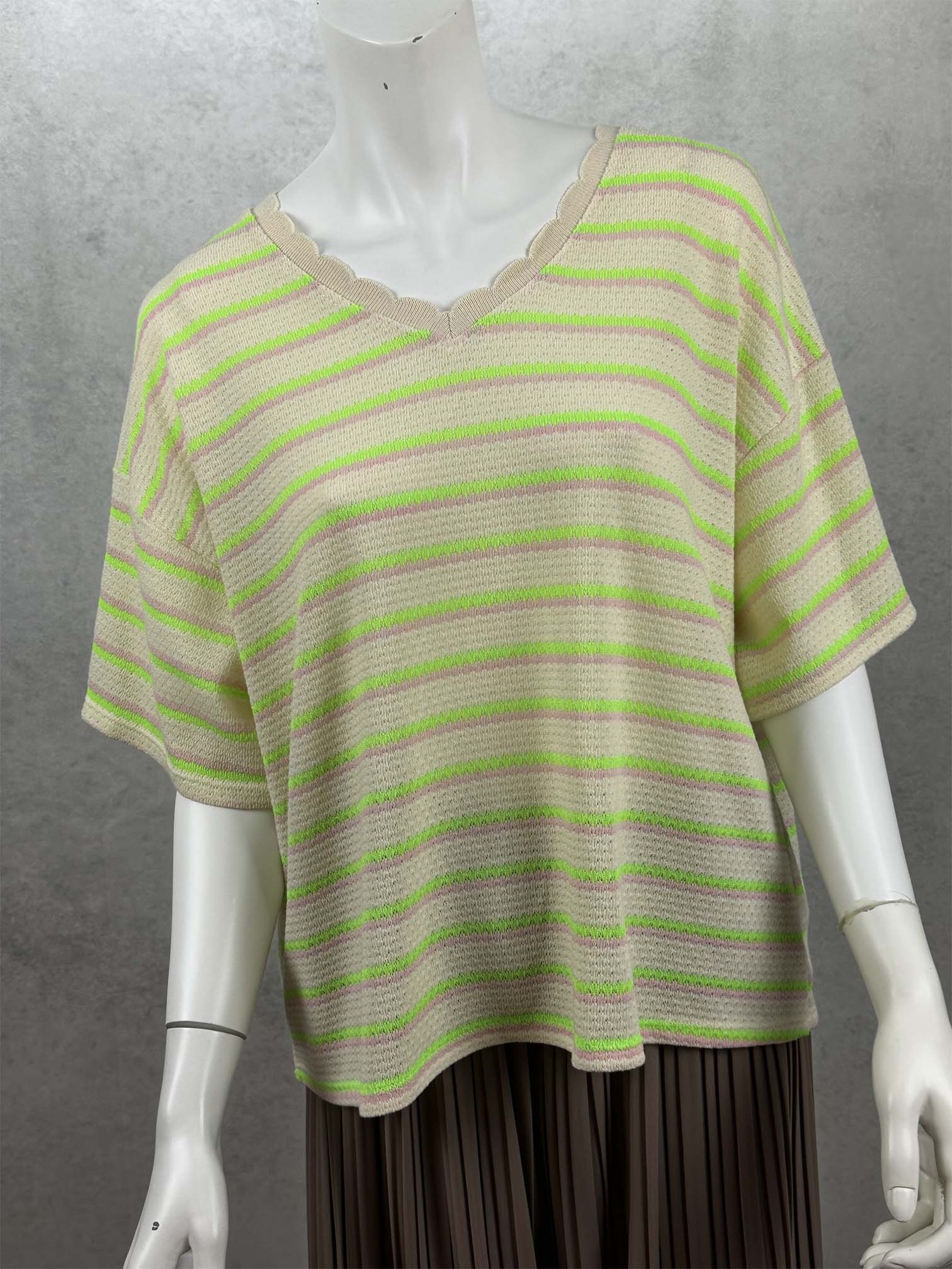 Moderner Strickshirt mit lockerer Passform, femininem V-Ausschnitt und auffaelligen Neonstreifen. Die weiche Strickstruktur und die kurzen Aermel machen ihn zum perfekten Begleiter fuer Fruehling und Sommer.