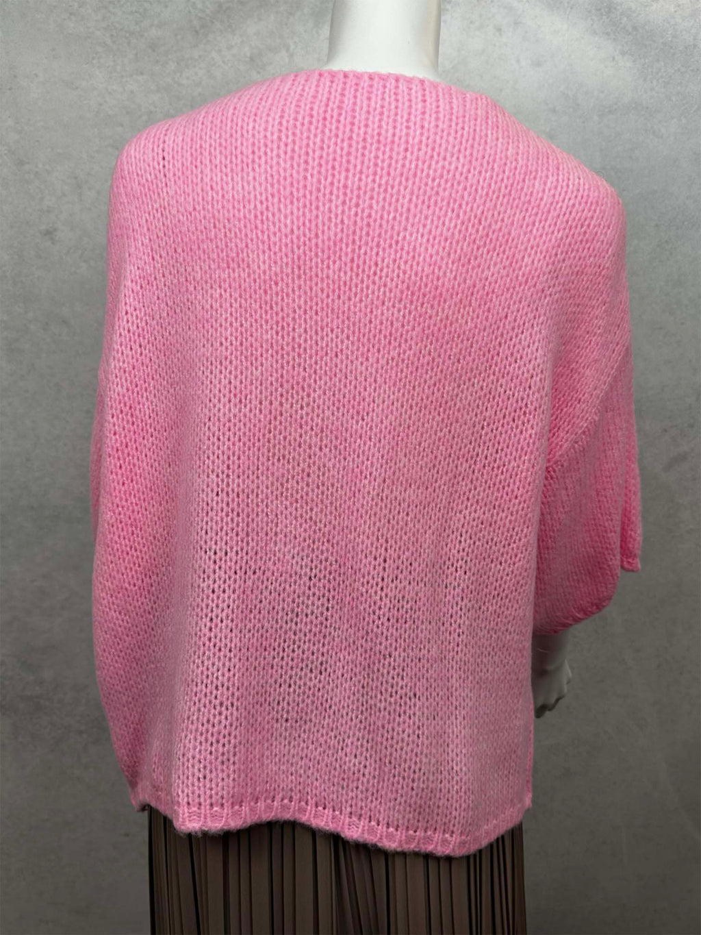 Rückansicht einer locker geschnittenen Strickjacke in Rosa