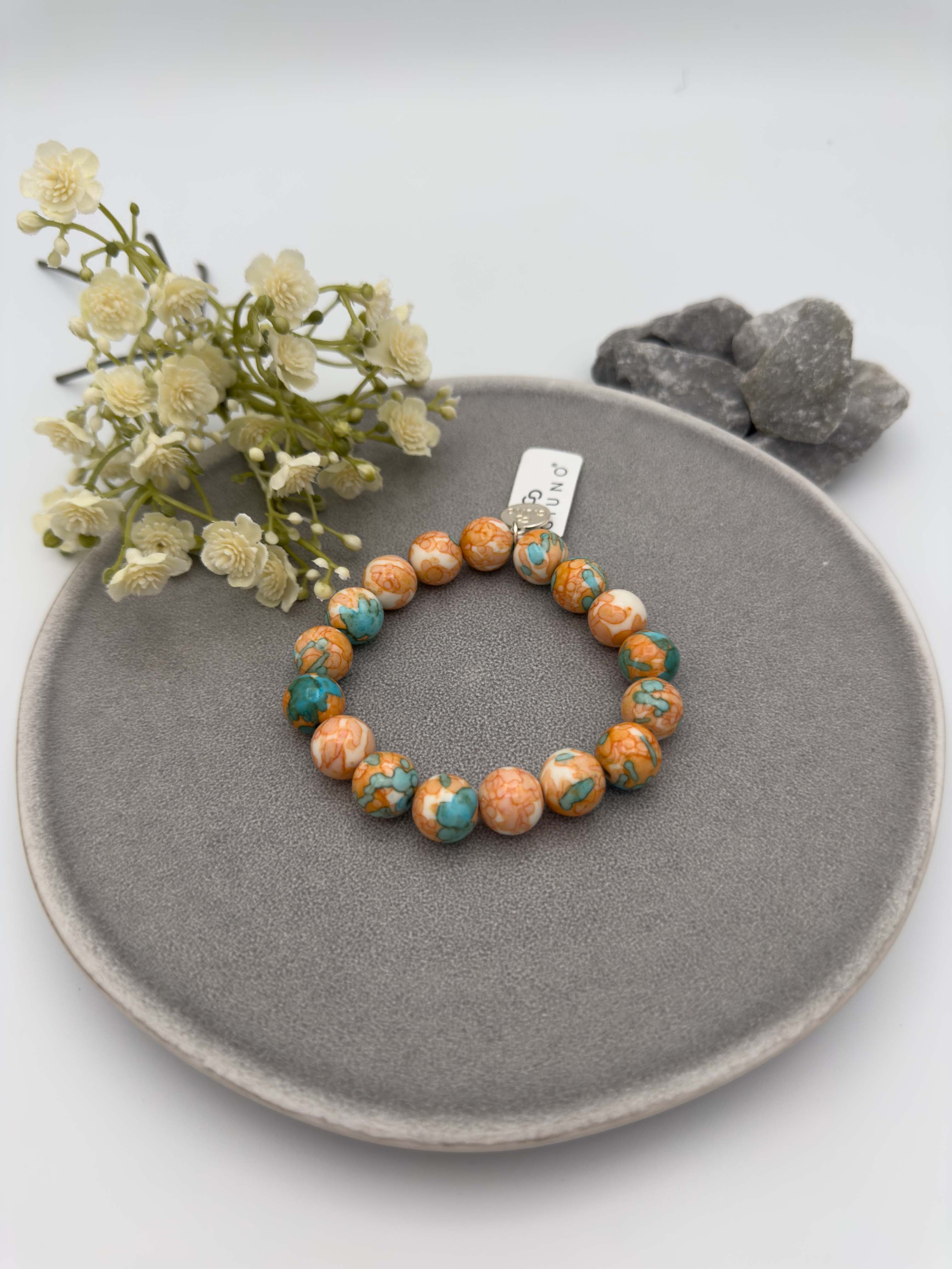 Elastisches Perlenarmband mit marmorierten Natursteinperlen in Orange und Tuerkis
