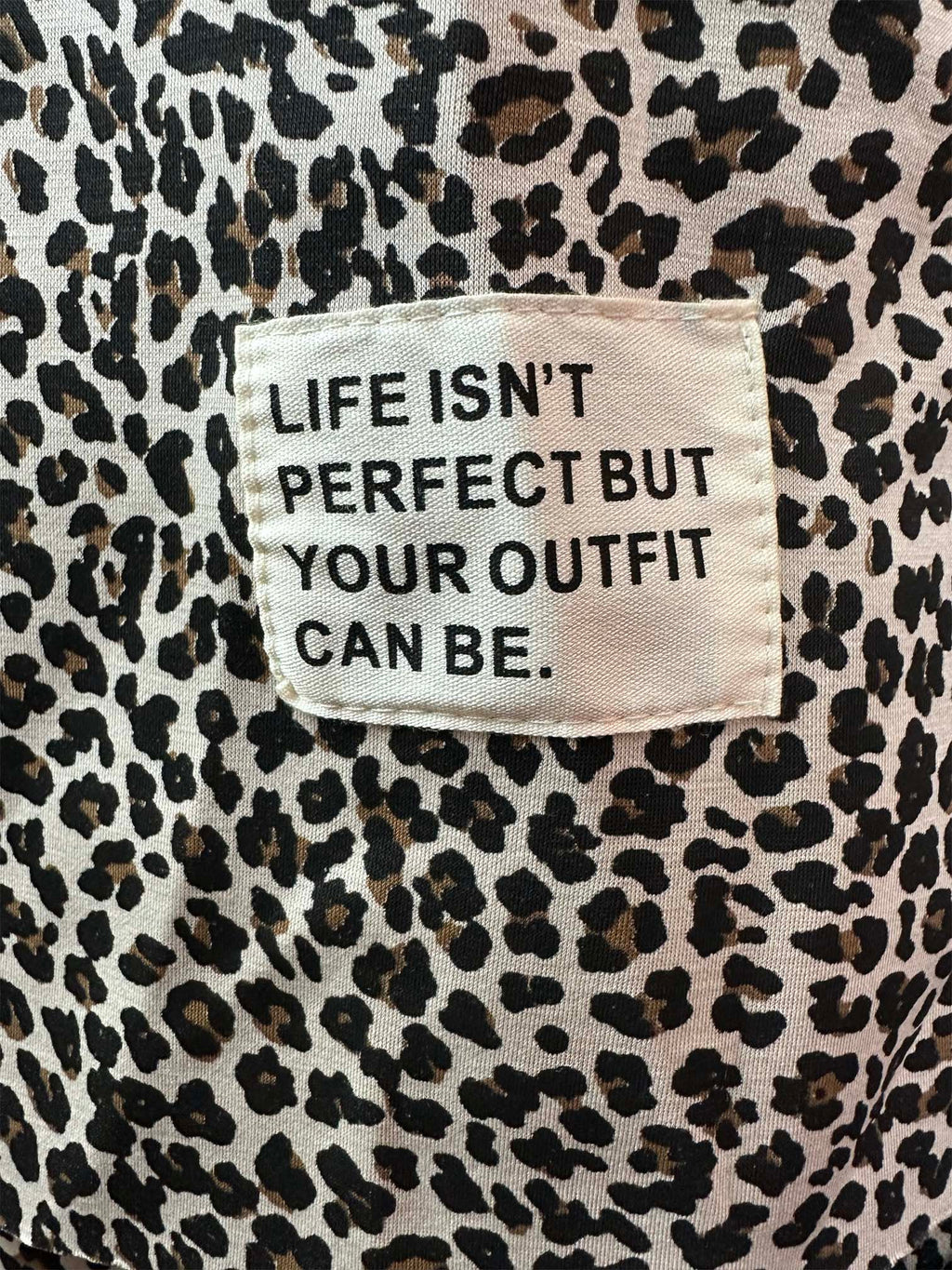 Stoffpatch mit Schriftzug „Life isn’t perfect but your outfit can be“ auf leopardgemustertem Stoff