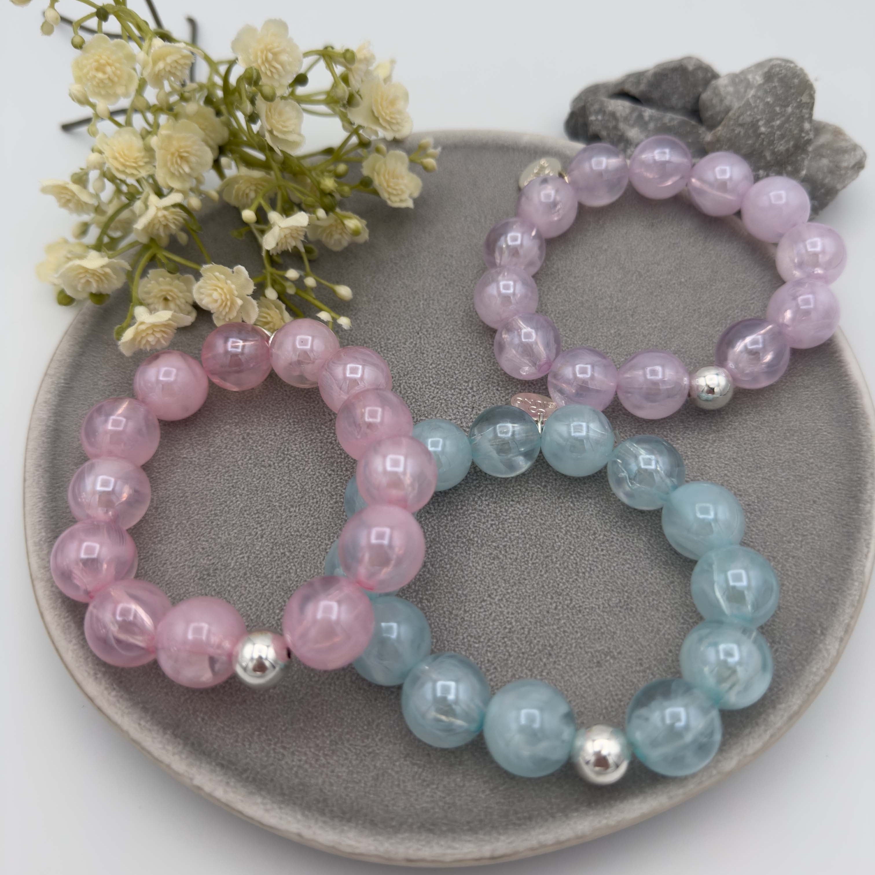 Elastische Damen Perlenarmbaender in Rosa, Hellblau und Lila mit silberfarbener Kugel als Akzent