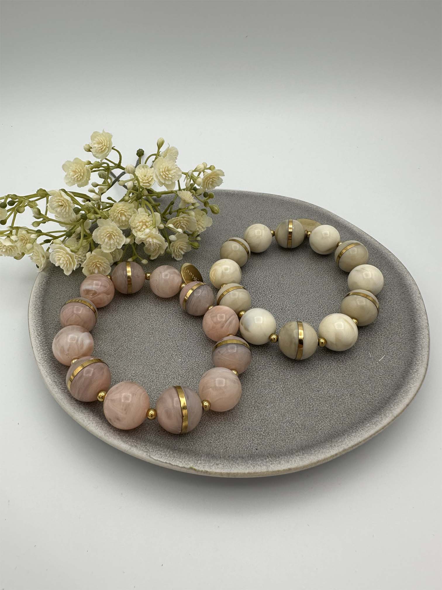 Zwei elastische Perlenarmbaender in Rosa und Creme mit goldfarbenen Zwischenelementen