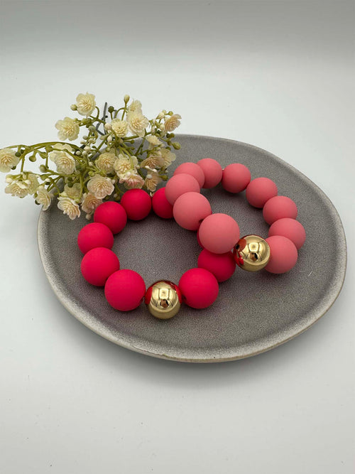 Zwei elastische Perlenarmbaender in Rosa und Pink mit goldfarbenen Kugeln 