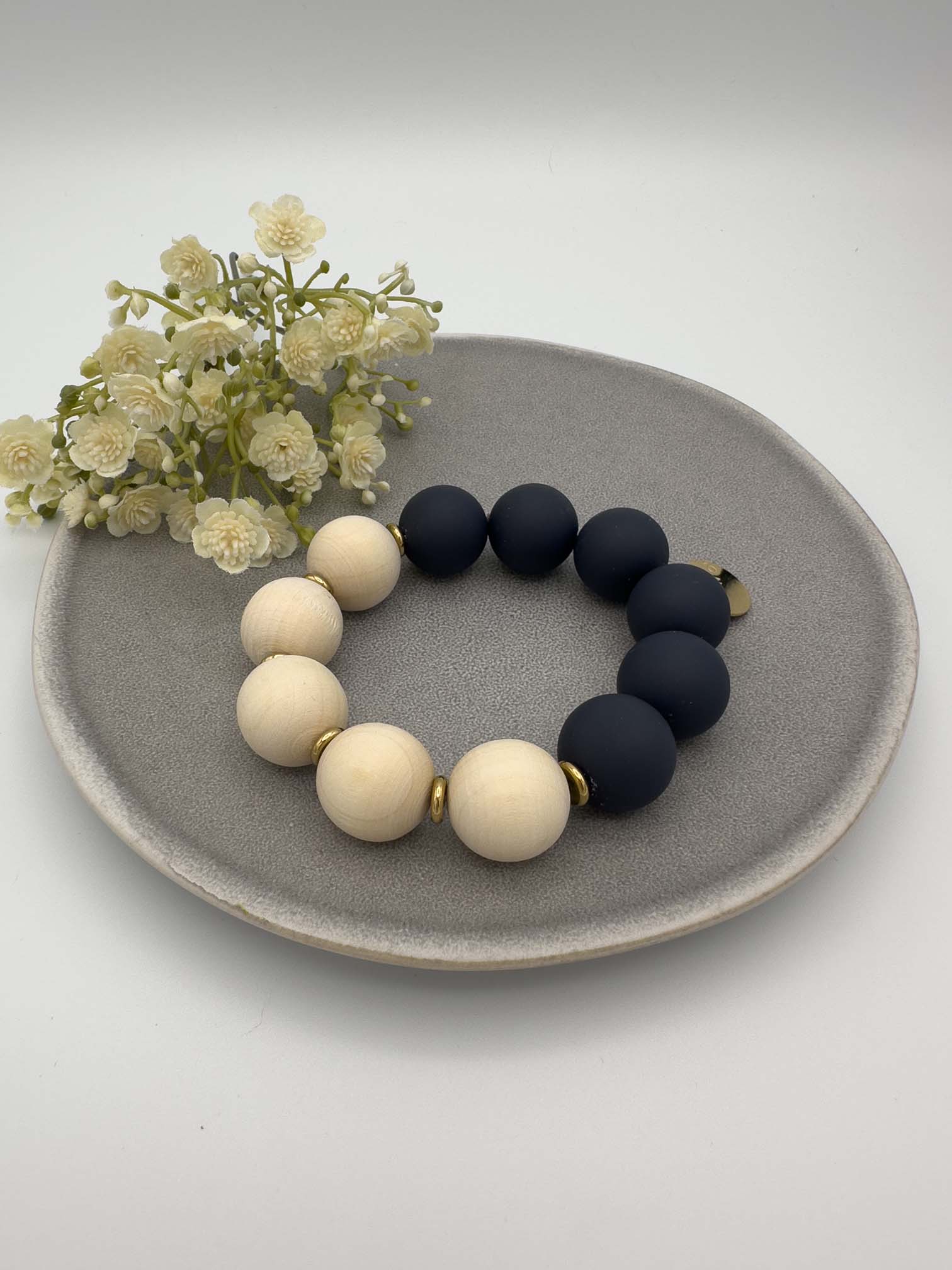 Elastisches Armband mit natur Holzperlen und dunkelblauen Perlen sowie goldenen Zwischenelementen