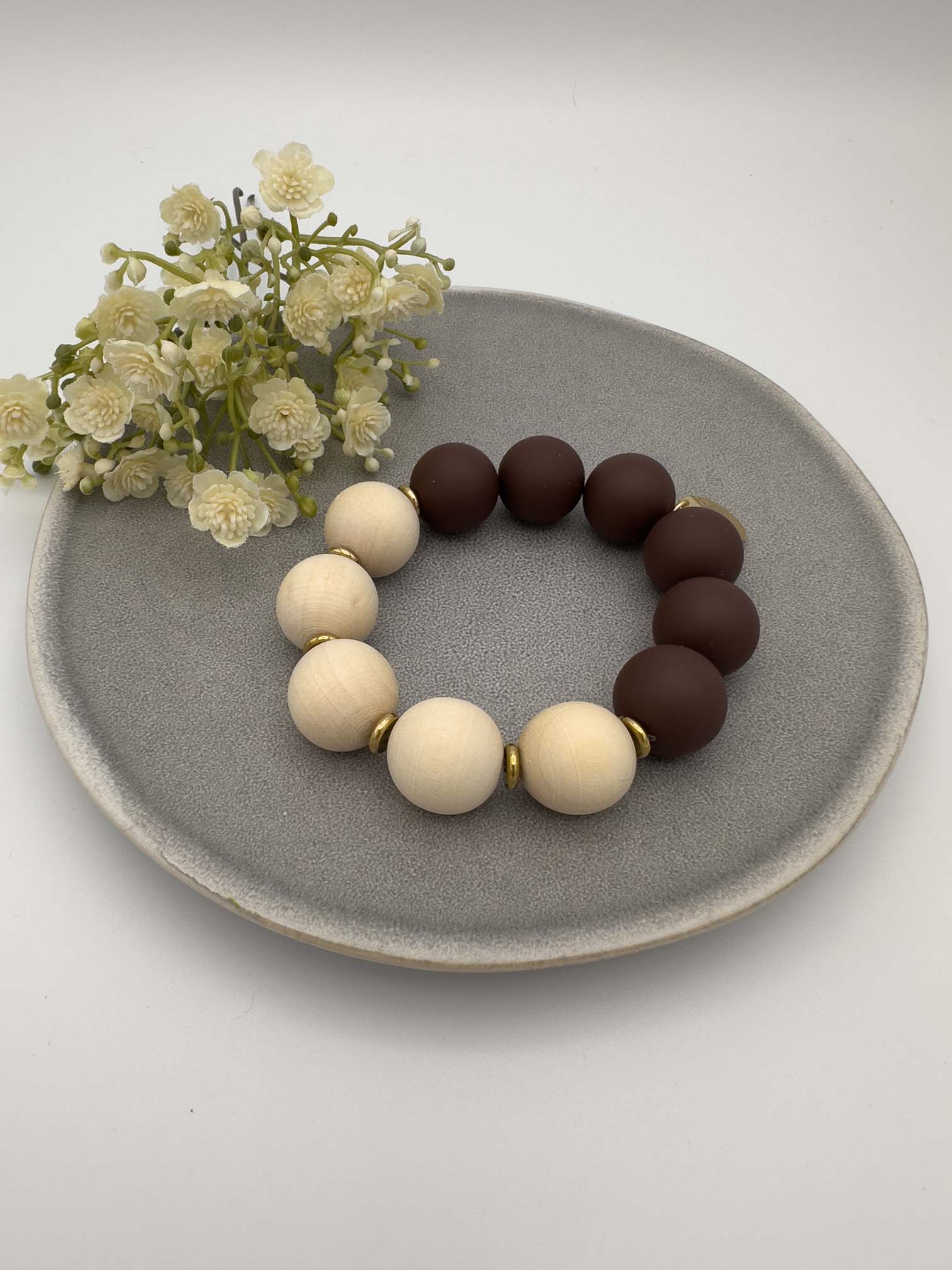 Elastisches Armband mit naturfarbenen Holzperlen und dunkelbraunen Perlen mit goldenen Zwischenelementen