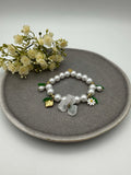 Elastisches Perlenarmband mit weissen Perlen sowie Blumen- und Erdbeeranhaengern