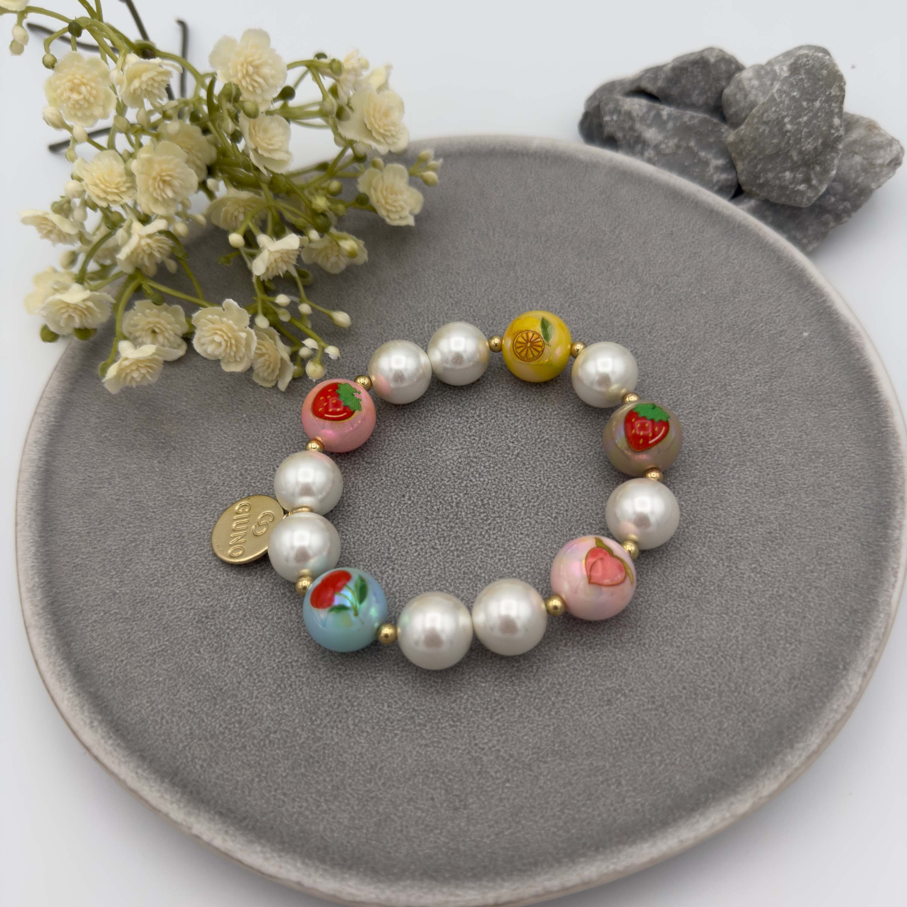 Elastisches Perlenarmband mit weissen Perlen und bunten Fruchtmotiven wie Erdbeere, Zitrone und Pfirsich