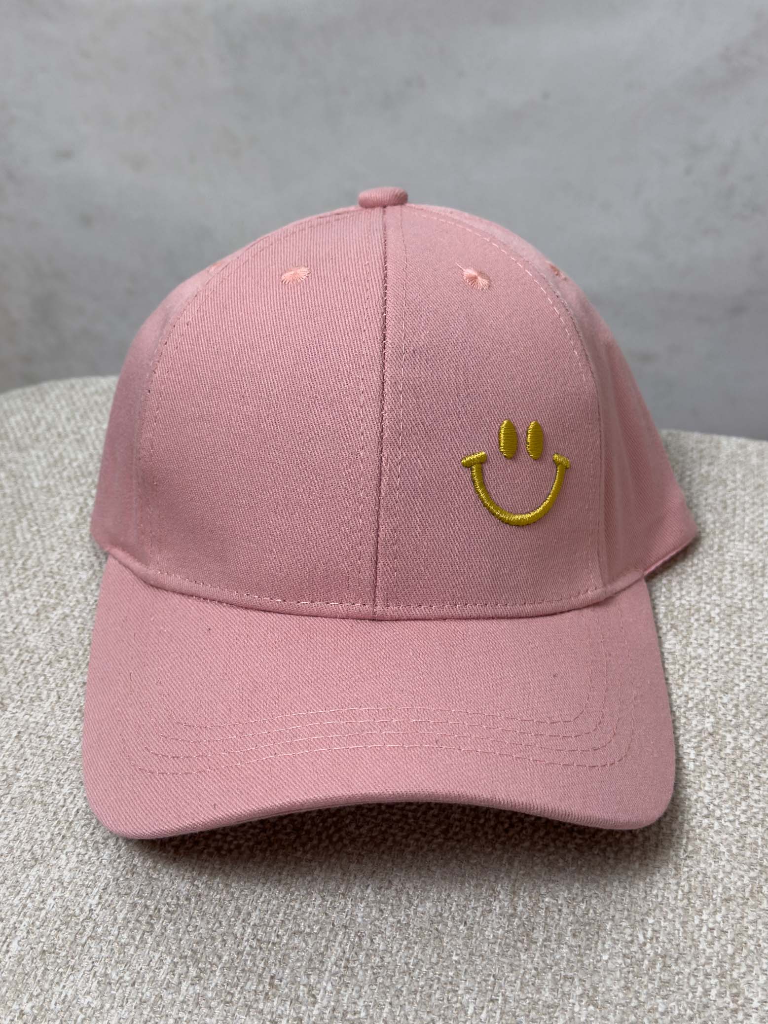 Rosa Baseball Cap mit gelb gesticktem Smiley auf der Vorderseite