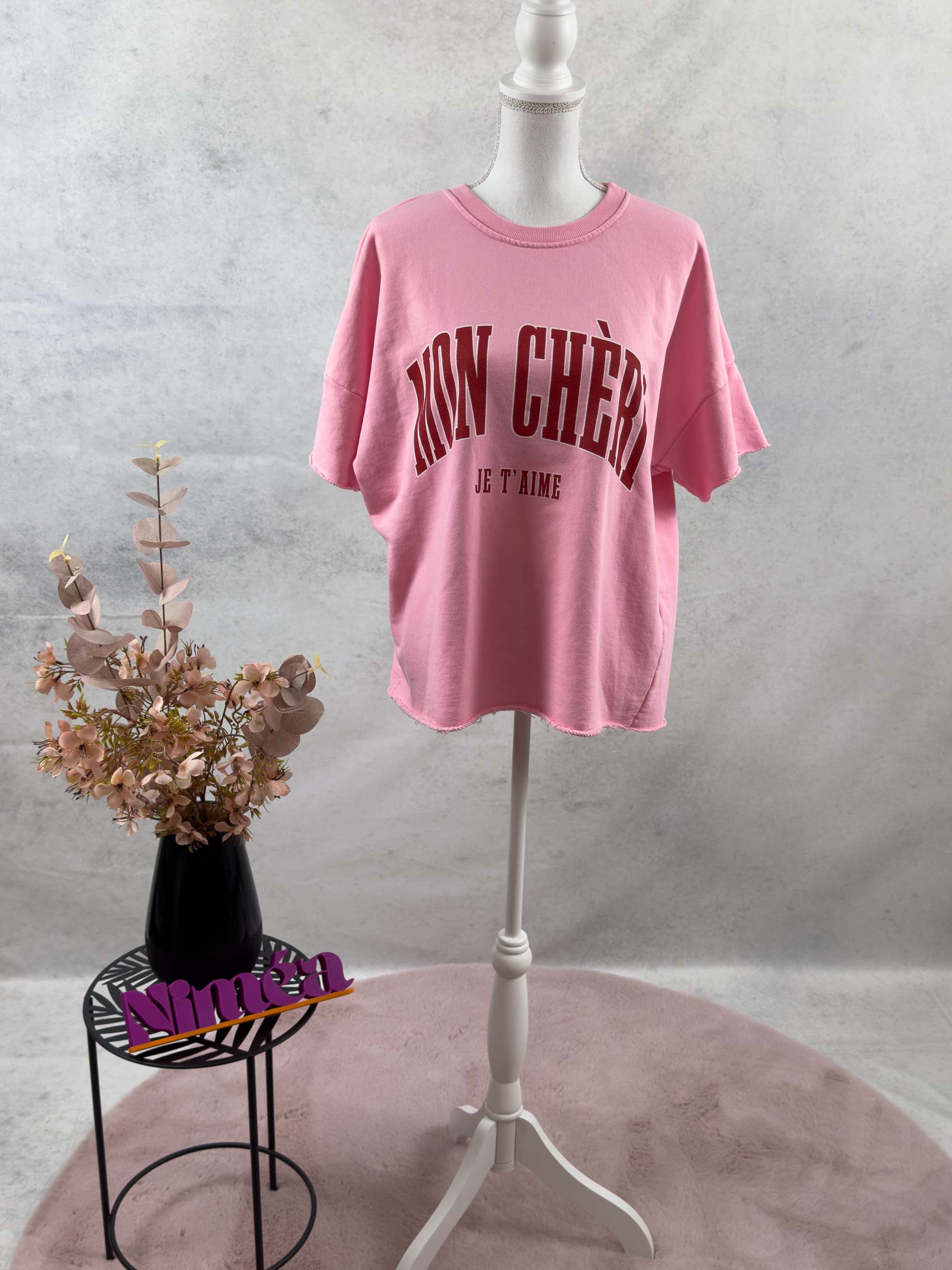 Freigestelltes Damen T Shirt in Rosa mit MON CHÈRI Schriftzug und JE T’AIME Print auf der Vorderseite