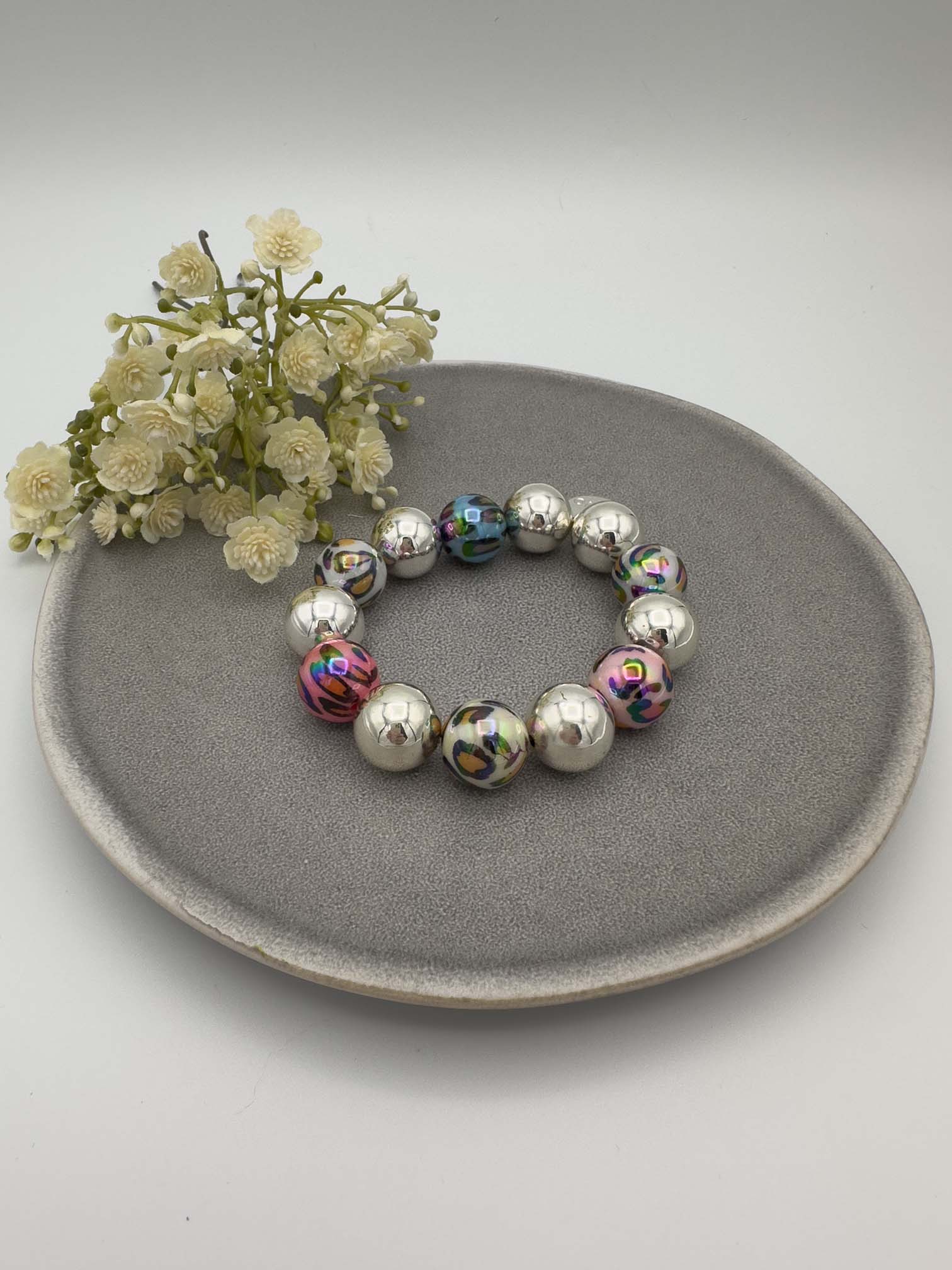 Elastisches Armband mit silberfarbenen Kugeln und blau schillernden Perlen im Leo Look