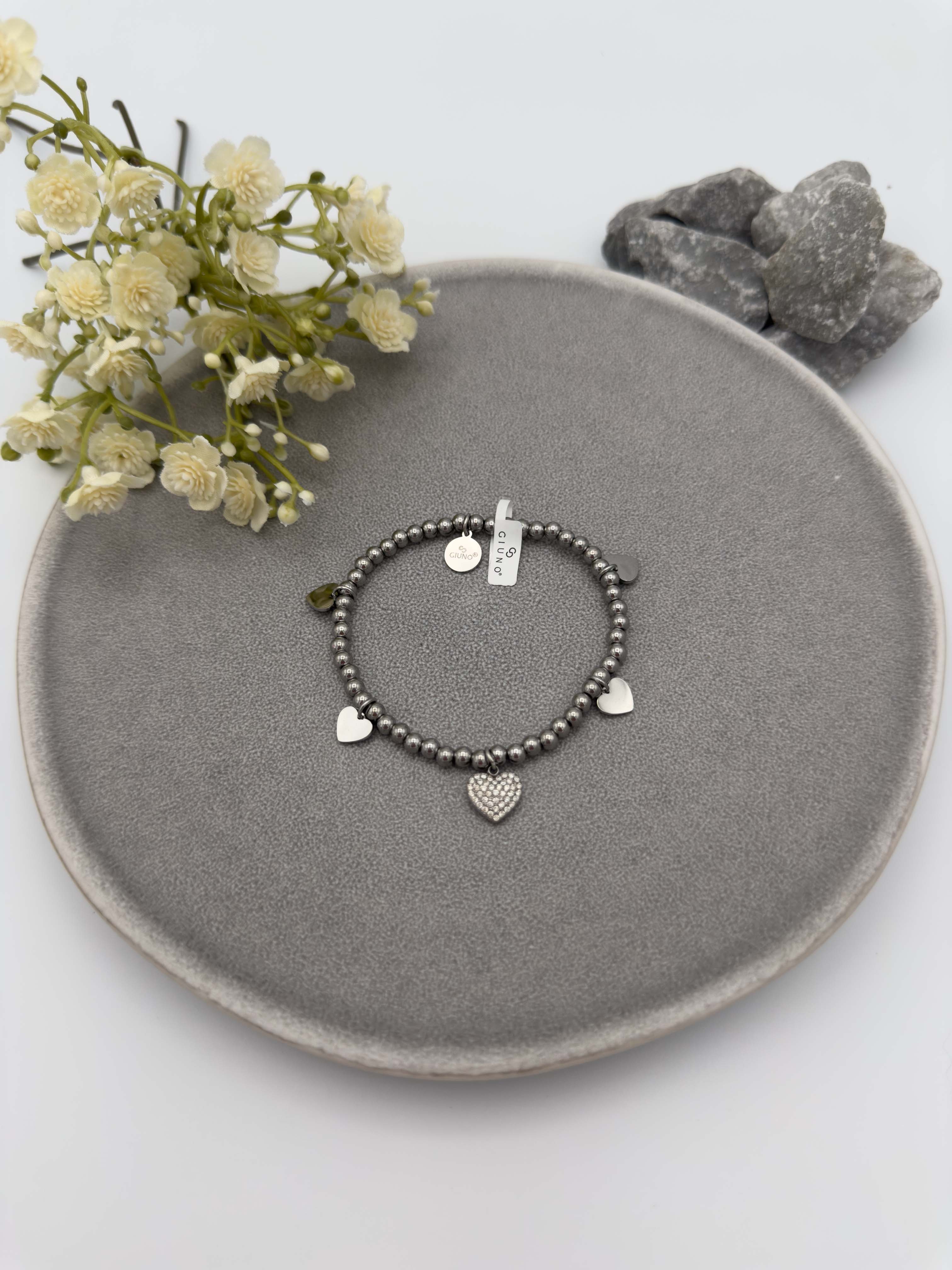Elastisches Armband mit silberfarbenen Metallperlen und Herzanhaenger