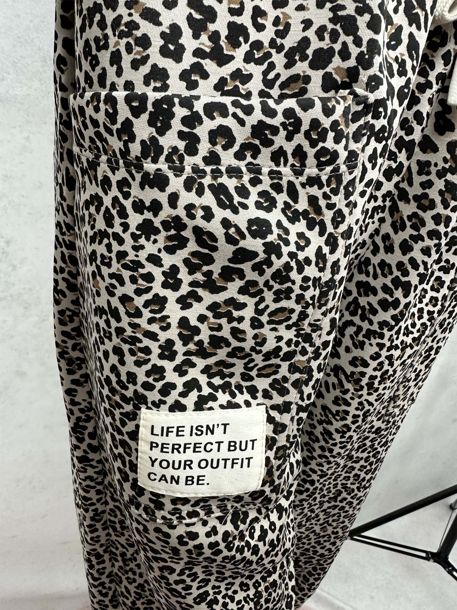 Stoffpatch mit Schriftzug „Life isn’t perfect but your outfit can be“ auf leopardgemustertem Stoff mit aufgenähter Tasche